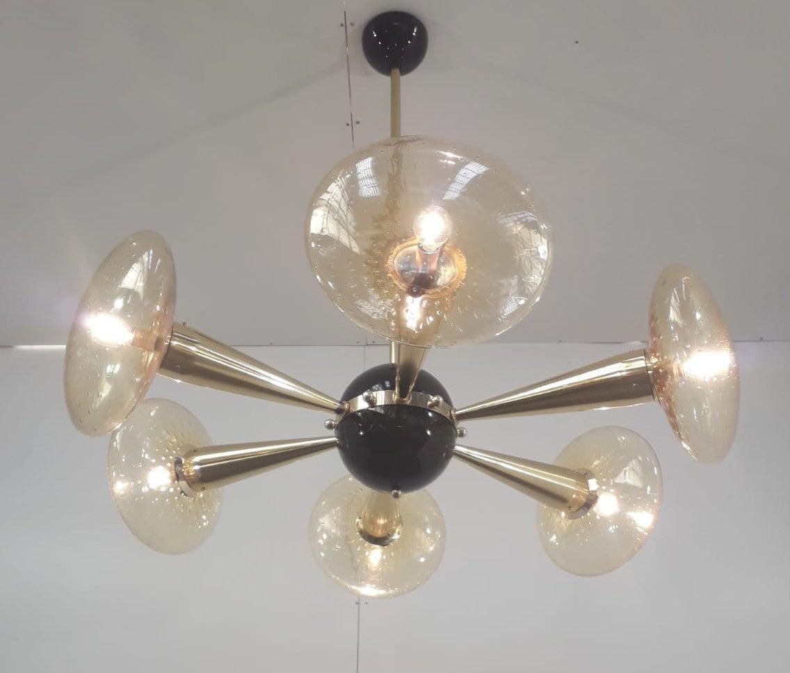 Italian chandelier with amber Murano glass shades hand blown with bubbles inside the glass using Bollicine technique, mounted on newly made polished brass frame with black enameled center and ceiling canopy, designed by Fabio Bergomi for Fabio Ltd,