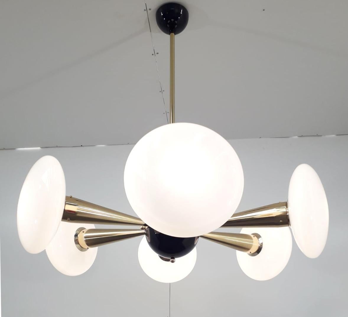 Italian chandelier with glossy white Murano glass shades mounted on polished brass frame with black enameled center and ceiling canopy / Designed by Fabio Bergomi for Fabio Ltd / Made in Italy 
6 lights / E12 or E14 type / max 40W each 
Measures: