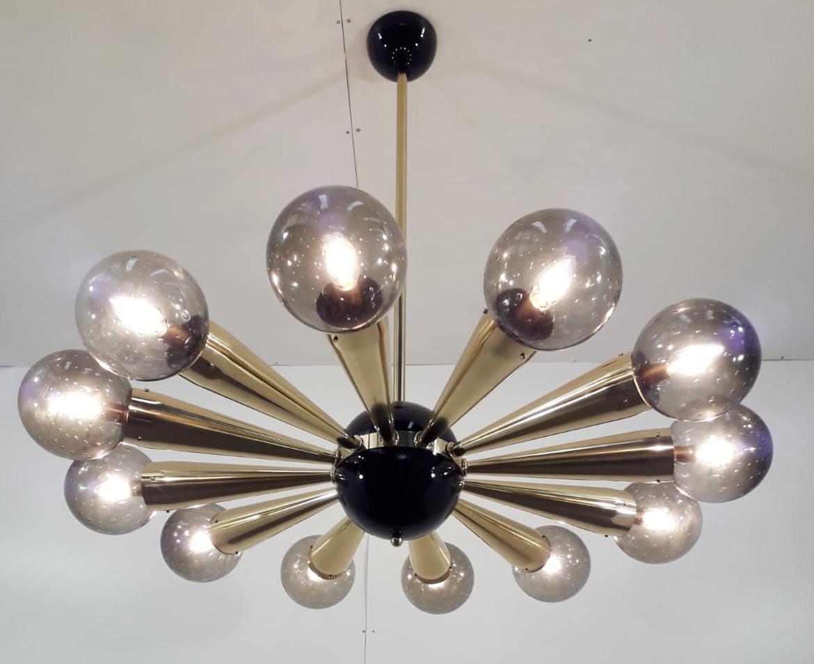 Italian chandelier with smoky Murano glass globes with carefully blown bubbles within the glass using Bollicine technique, mounted on polished brass frame with black enameled center and ceiling canopy / Designed by Fabio Bergomi for Fabio Ltd / Made