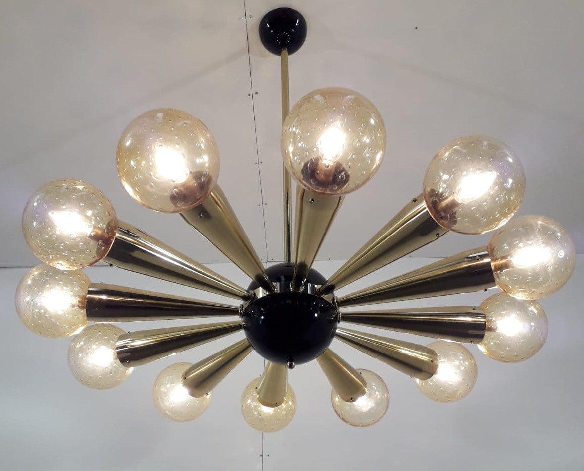 Italian chandelier with amber Murano glass globes with carefully blown bubbles within the glass using Bollicine technique, mounted on polished brass frame with black enameled center and ceiling canopy / designed by Fabio Bergomi for Fabio Ltd, made