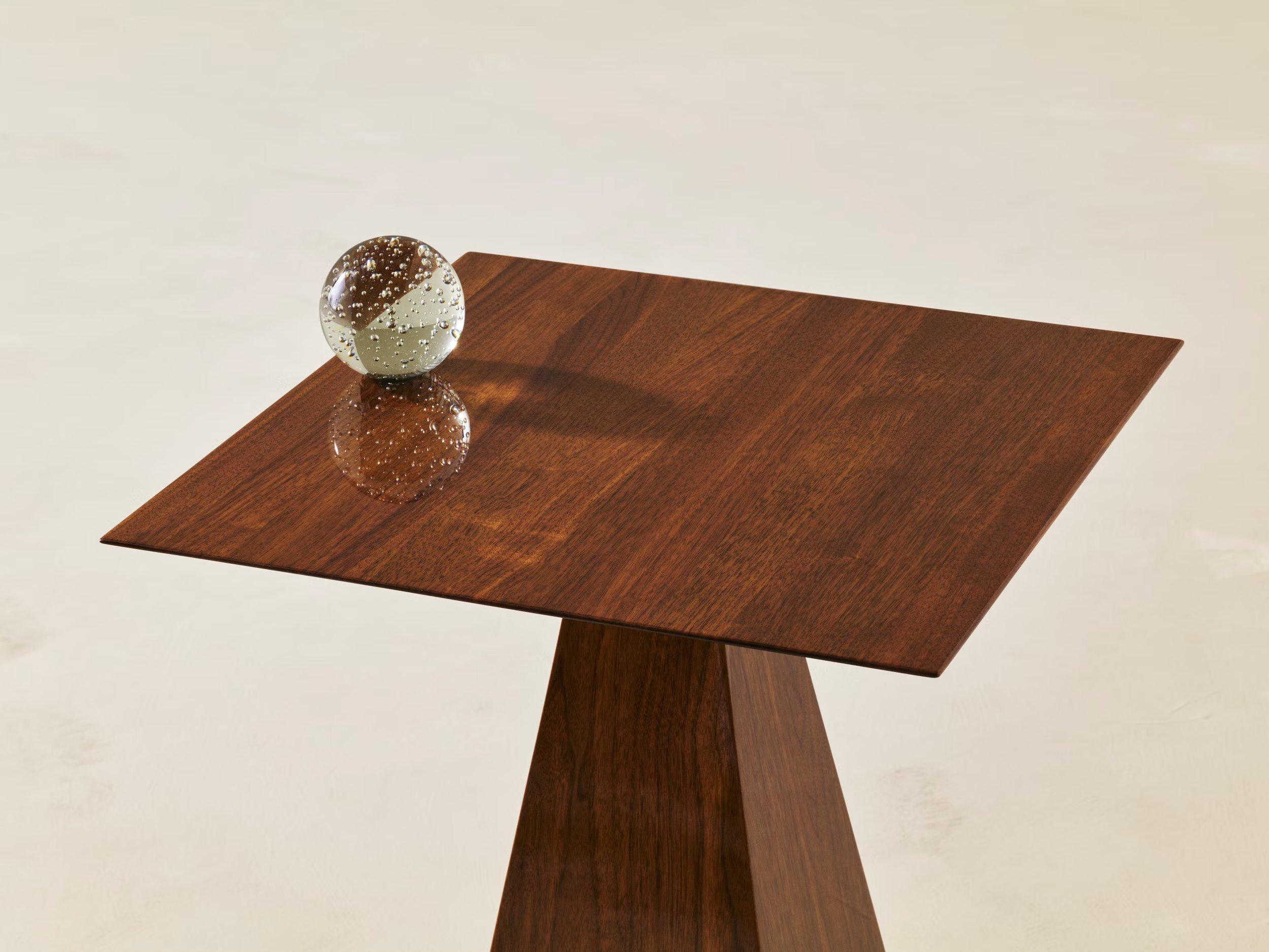 A sculptural side table with crisp corners and precise angles that reach up to support the finely edged tabletop, showcasing the wood grain beautifully. The SFS (Small Finicky Square Side Table) is a deceptively simple design that focuses attention