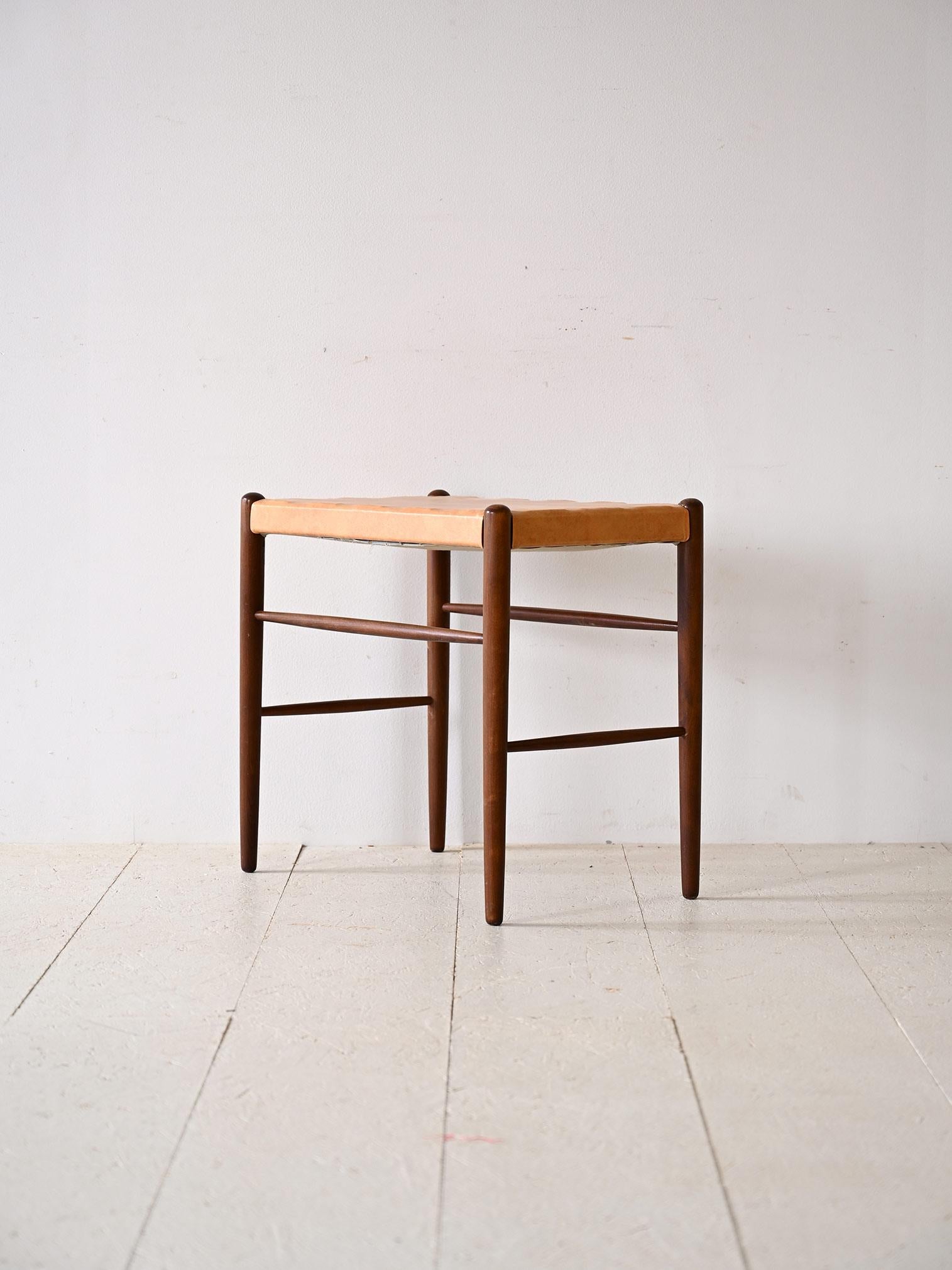 Original Scandinavian stool from the 1960s.

A piece of furniture with a classic flavor, consisting of a wooden frame formed by long conical legs and a beige leatherette seat.
It can be used in different rooms of the house to give a retro and