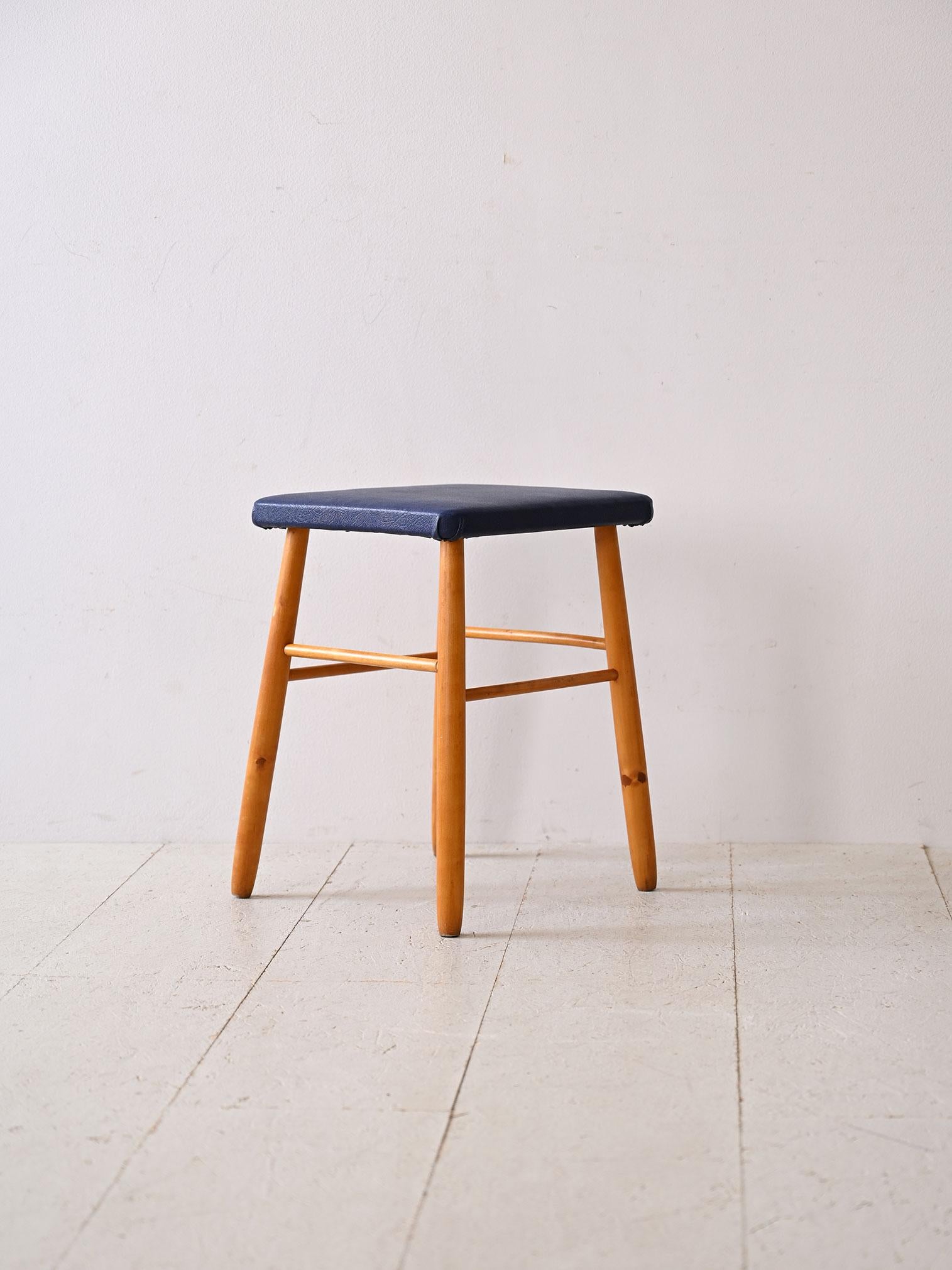 Small vintage stool, perfect for adding functionality and style to any space.                                                                                                   With its tapered wooden legs and dark blue leatherette upholstered seat,