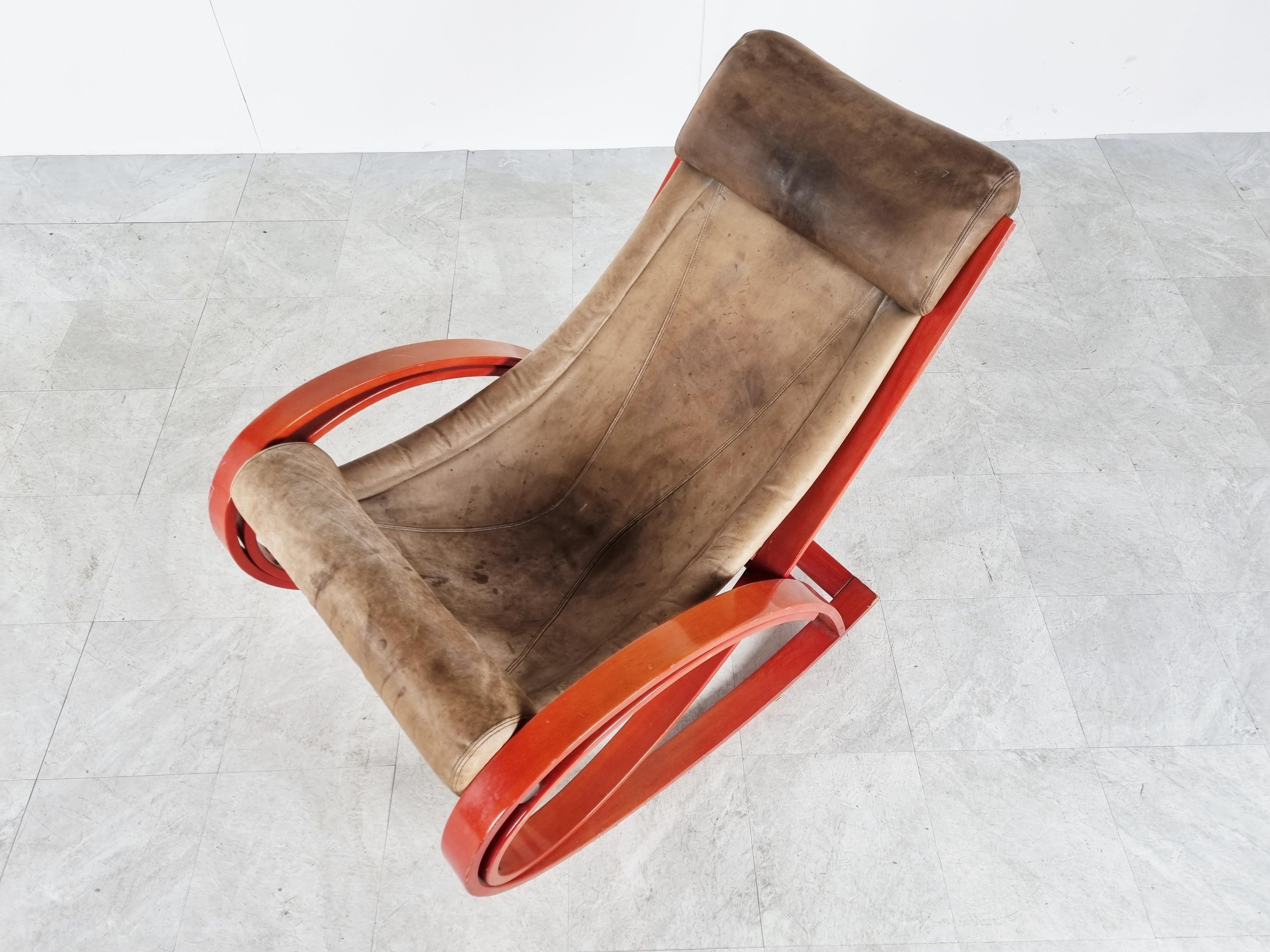 This great Sgarsul rocking chair was designed by Gae Aulenti in 1962 for Poltronova.

Consists of a red lacquered bentwood frame with nicely patinated brown leather seats/upholstery.

Good overall condition, strong leather, no