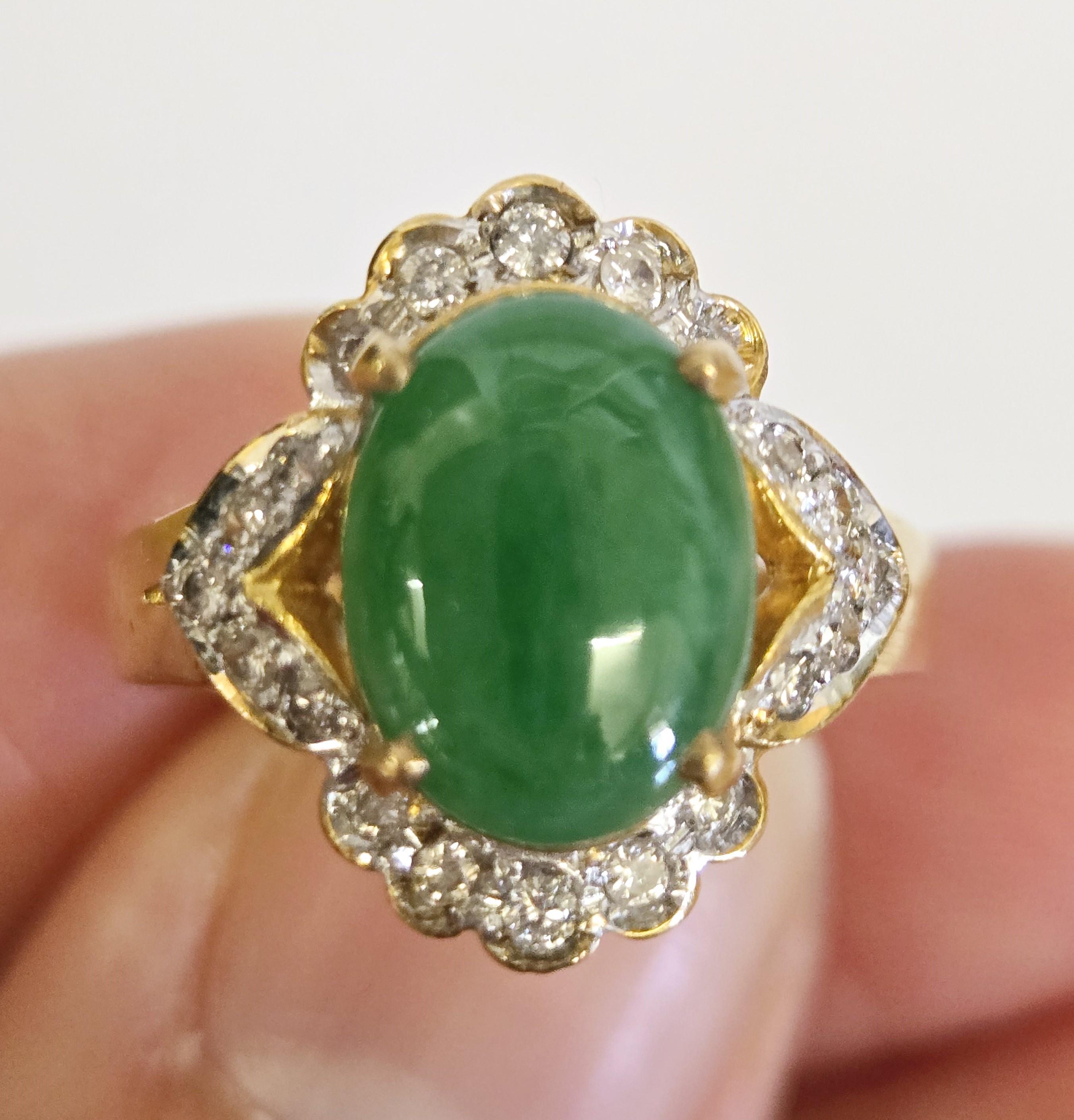Featuring a natural bright green oval cabochon of jadeite jade, this piece is beautifully framed by 20 natural round diamonds set in yellow gold. It comes with a Superior Gemological Laboratory report, confirming the jadeite jade as natural with no