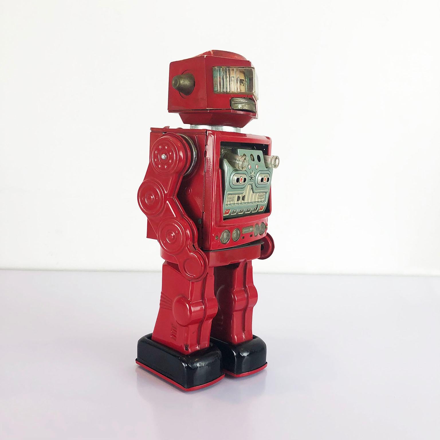 This battery operated robot was made in Japan and is circa 1970s. Walks forward and then stops and rotates 360 degrees as the chest doors drop and fire lighted guns!