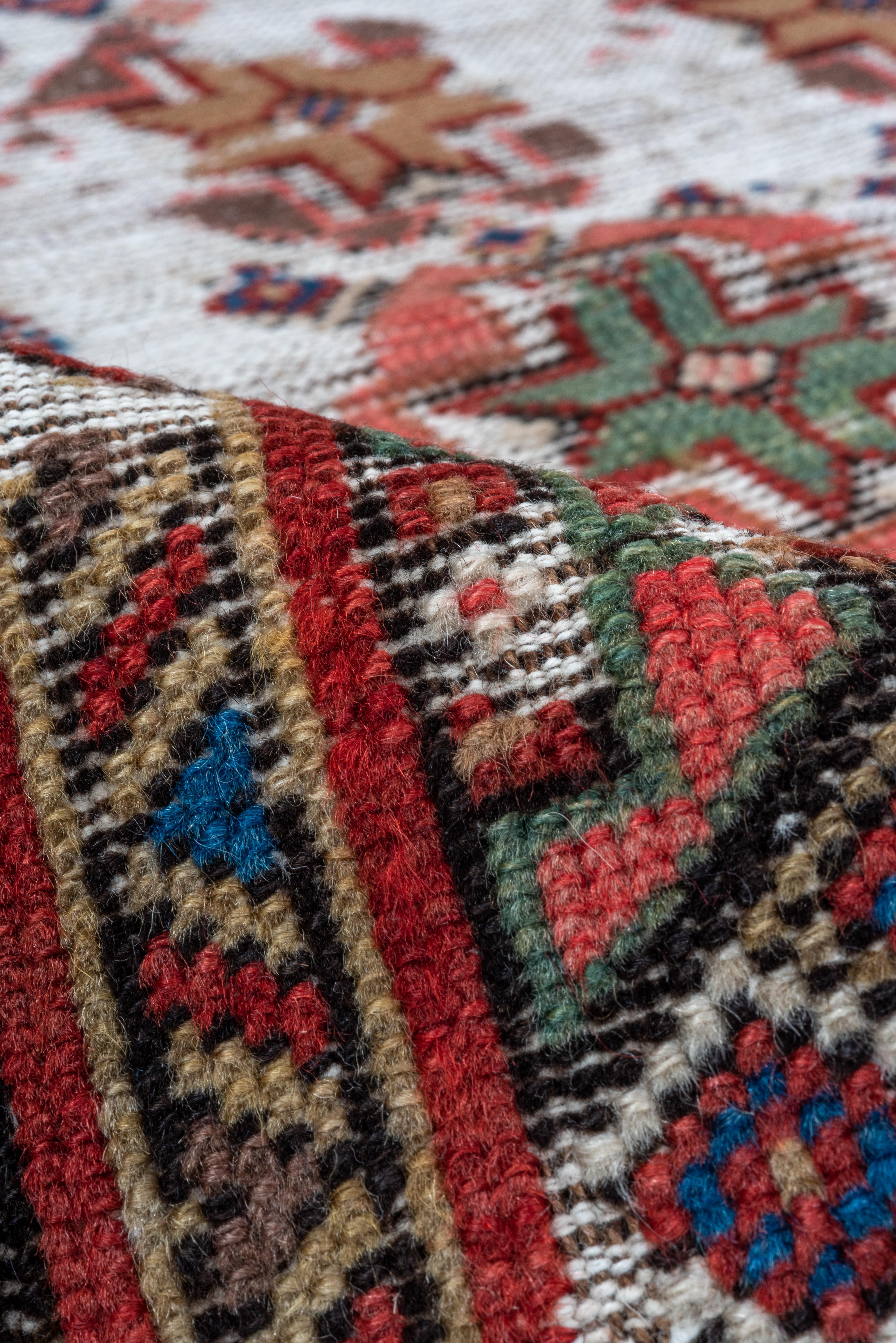 A vibrant expression of Persian craftsmanship, this Malayer rug (3.7 x 5.4) features a striking geometric design enriched with a warm palette of reds, blues, and earthy tones. The intricate motifs and finely detailed borders showcase the meticulous