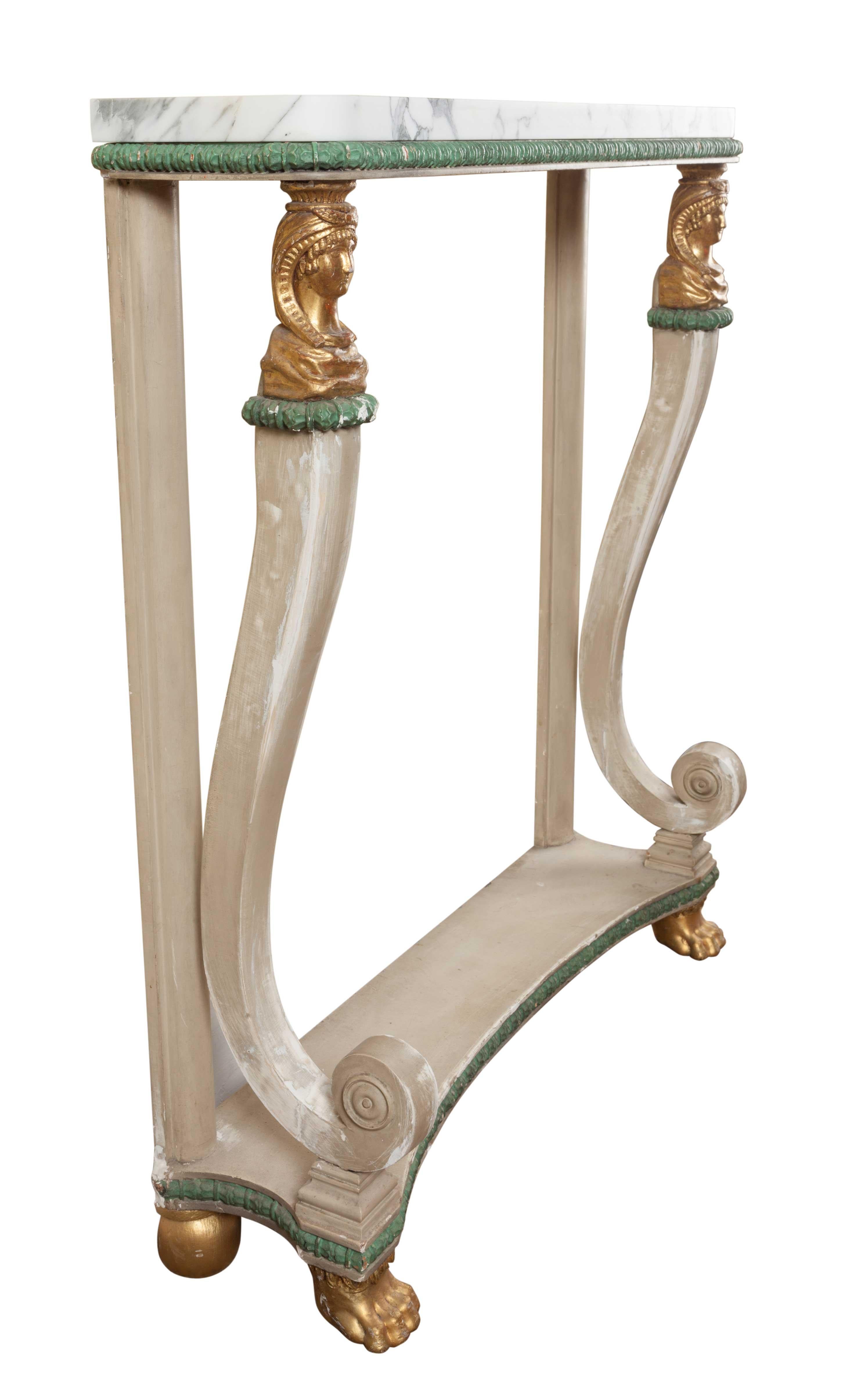 Shabby chic painted Empire console table, circa 1815.
Grey/green painted console table with Carrera marble top, carved beaded frieze supported by two gilded Egyptian heads with carved cabriole scrolls, terminating on a inverted platform base,