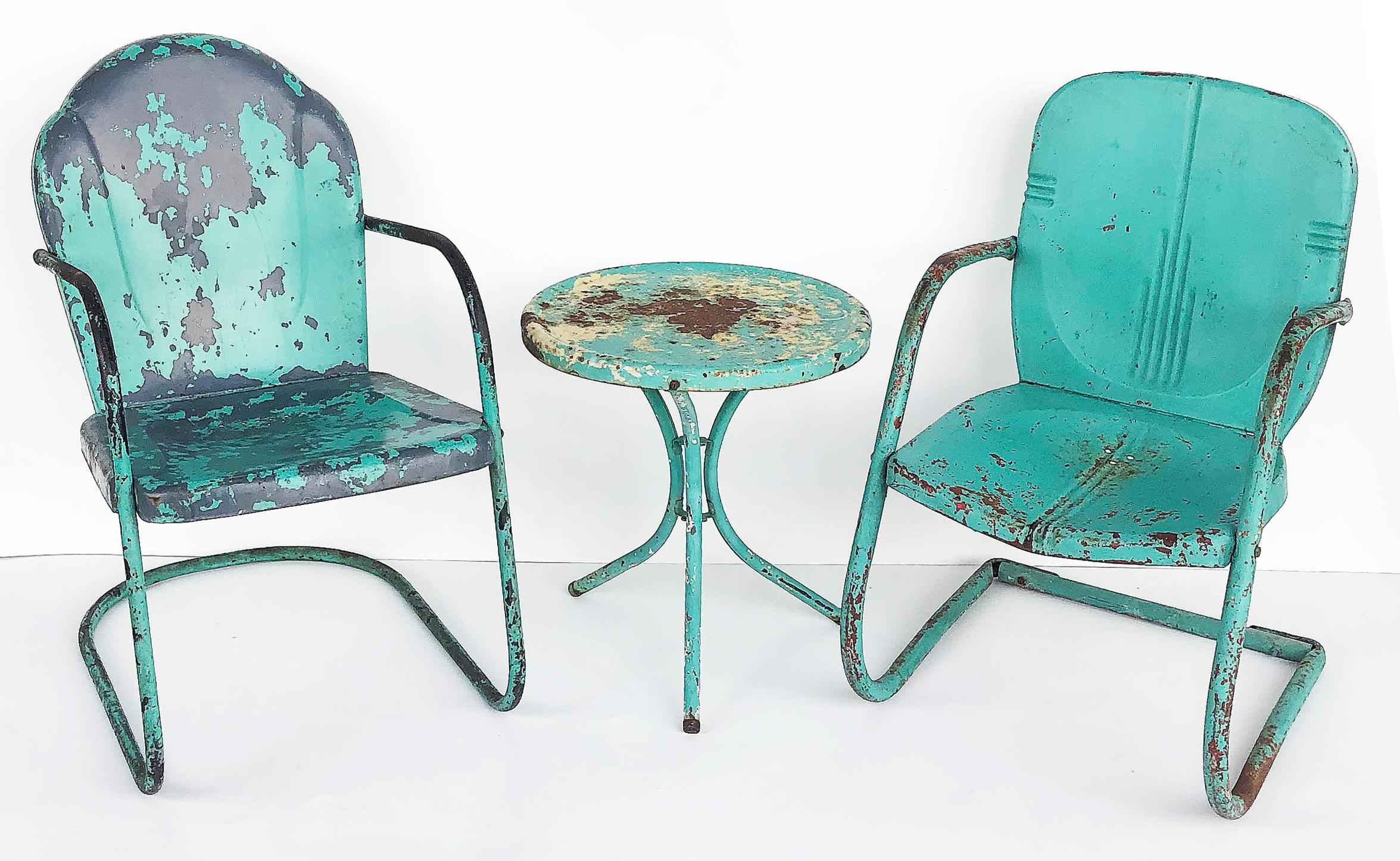 Shabby chic painted metal garden chairs & table set of 3

Offered for sale is a vintage Mid-century Modern set of two similar iron cantilever garden chairs and a companion side table. The set had last been painted turquoise over previous colors.