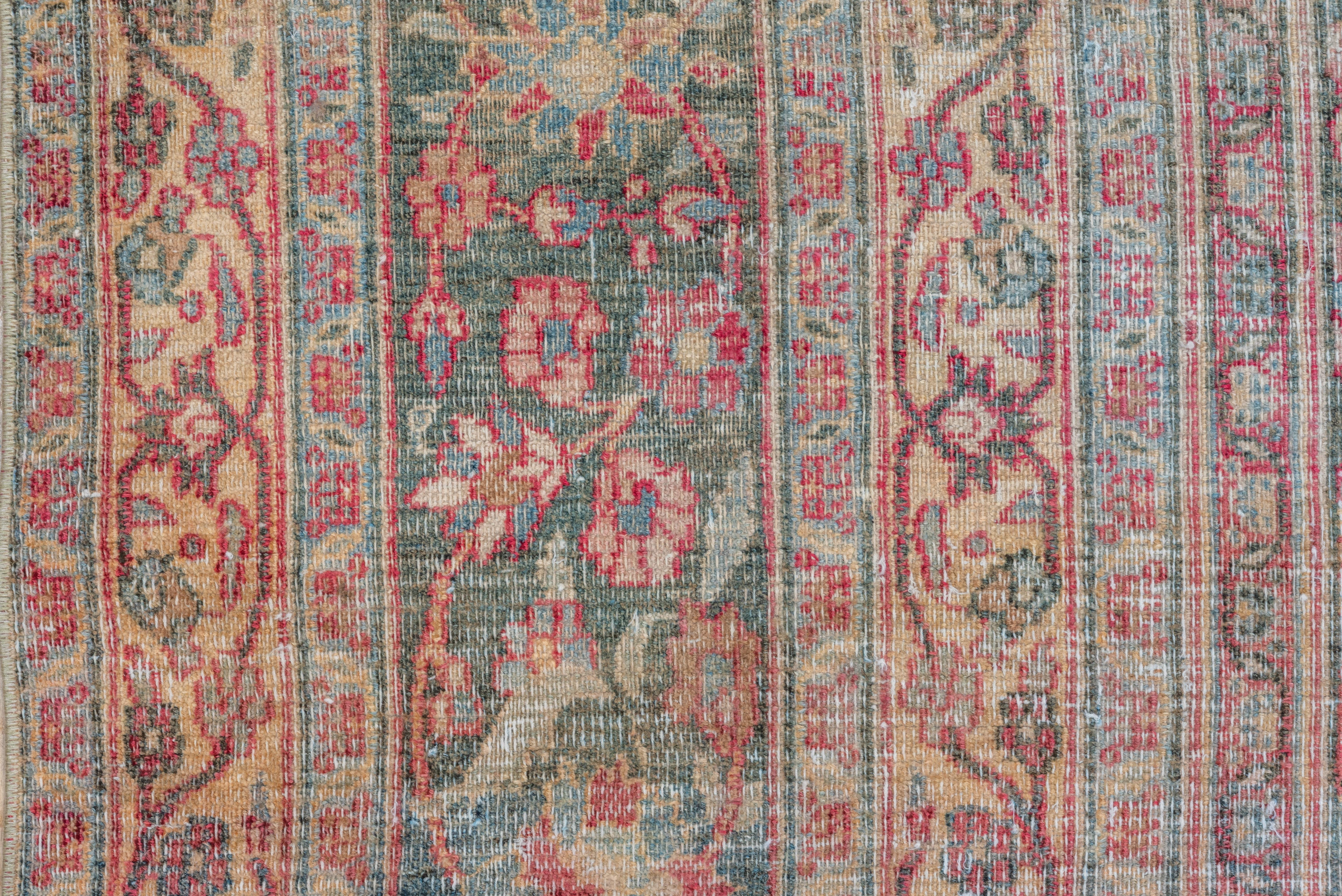 This distressed workshop carpet of medium fine weave shows a red field edged with acanthus leaves, and centred by a pointed and lobed slate medallion, within lighter blue corners, all decorated with palmettes, barbed lancet leaves and little