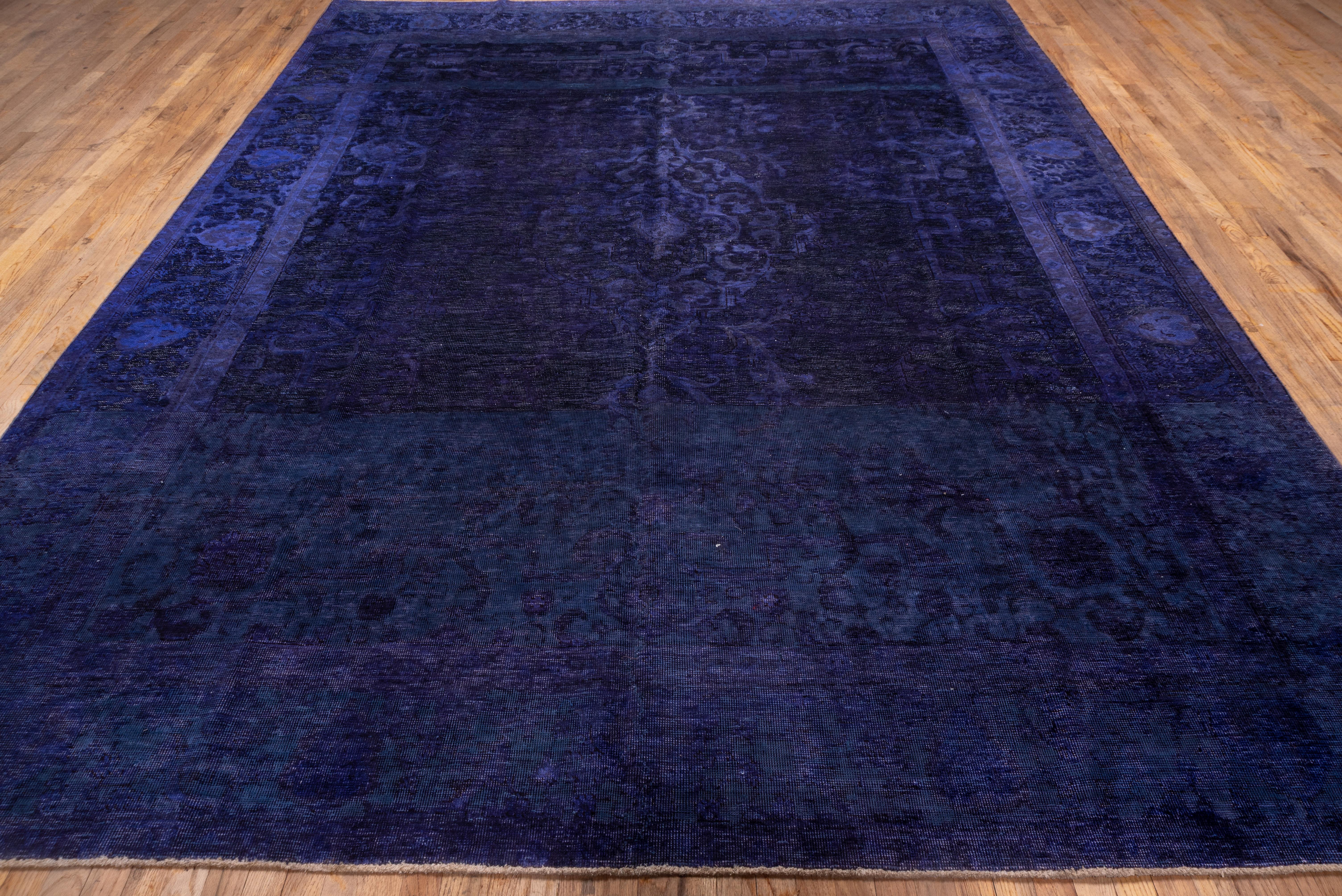 A crisp, saturated purple overdye on a palmette patterned carpet with additional palmetes in the bord. Pile flat to uniformly distressed, medium weave, cotton foundation. Overdye dominates pattern here. Great way to make a splash in a room that