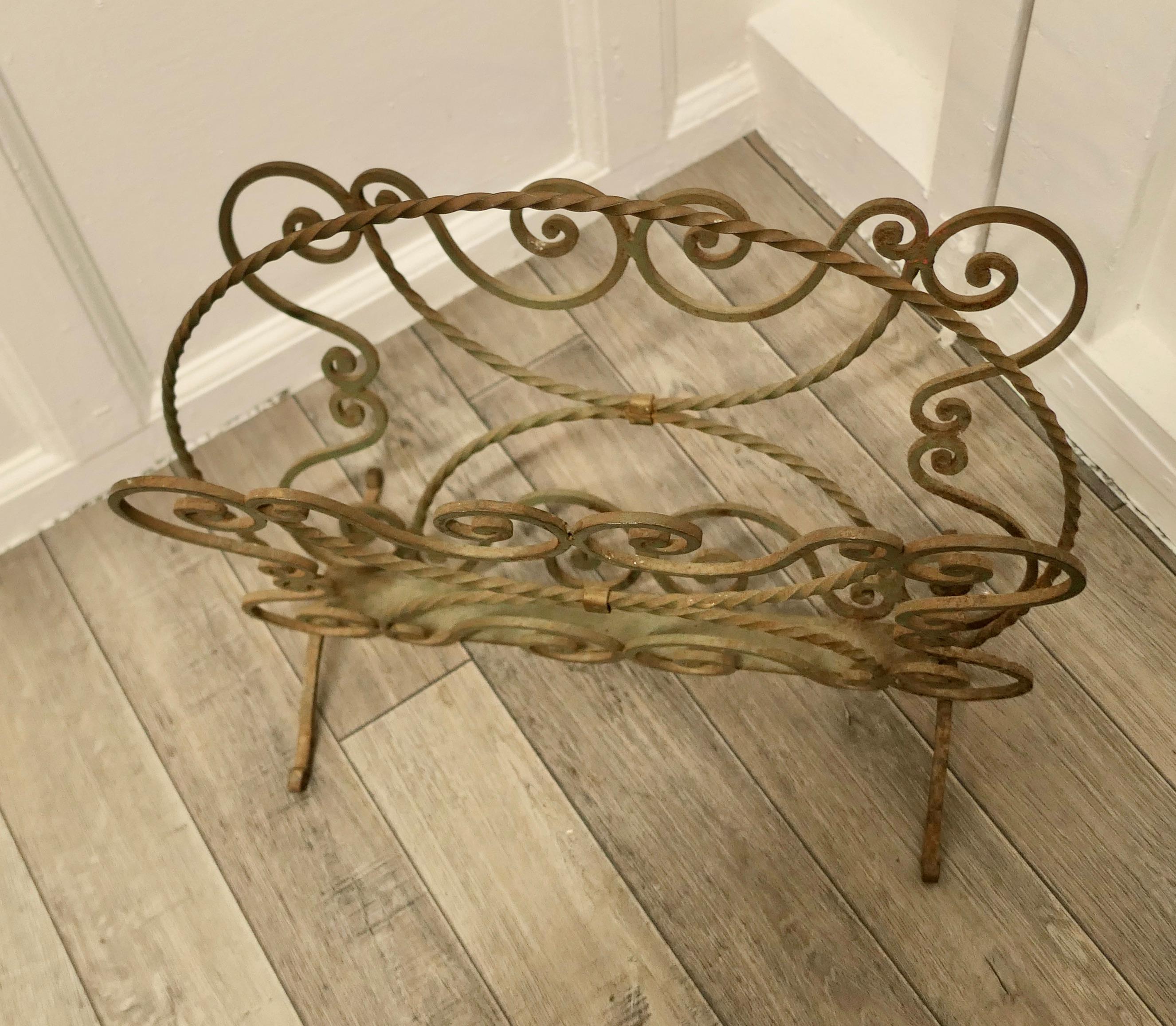 Shabby green wrought iron magazine rack

This is a very stylish piece, made in wrought iron, it has 2 magazine sections and it stands on neat legs and has a twisted hoop-over handle 
A good stylish looking piece and it is in good sound used