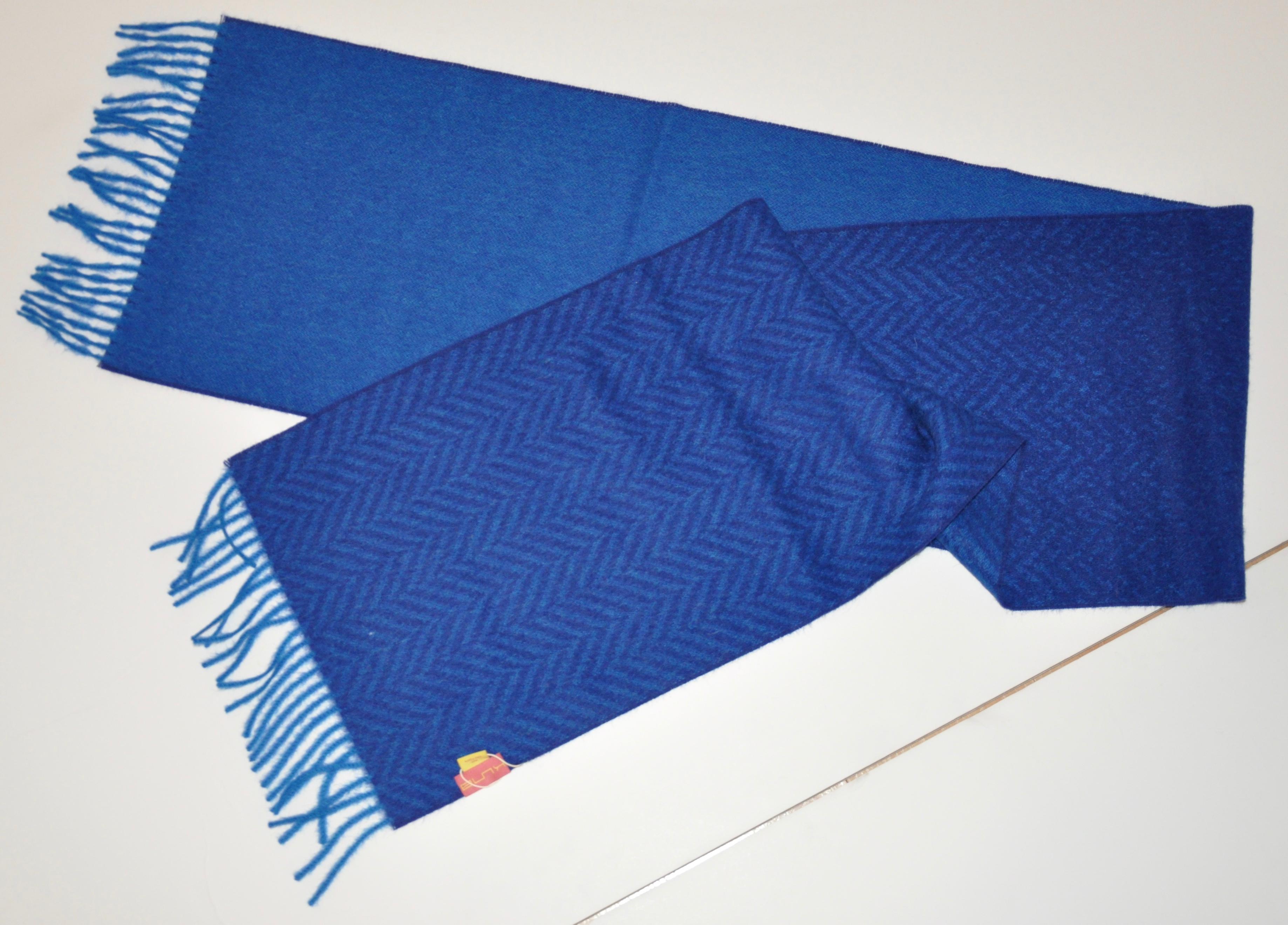      Shades of rich lapis-blue and herringbone-print baby alpaca fringed scarf measures 70 inches by 11 1/2 inches. Made in Peru.