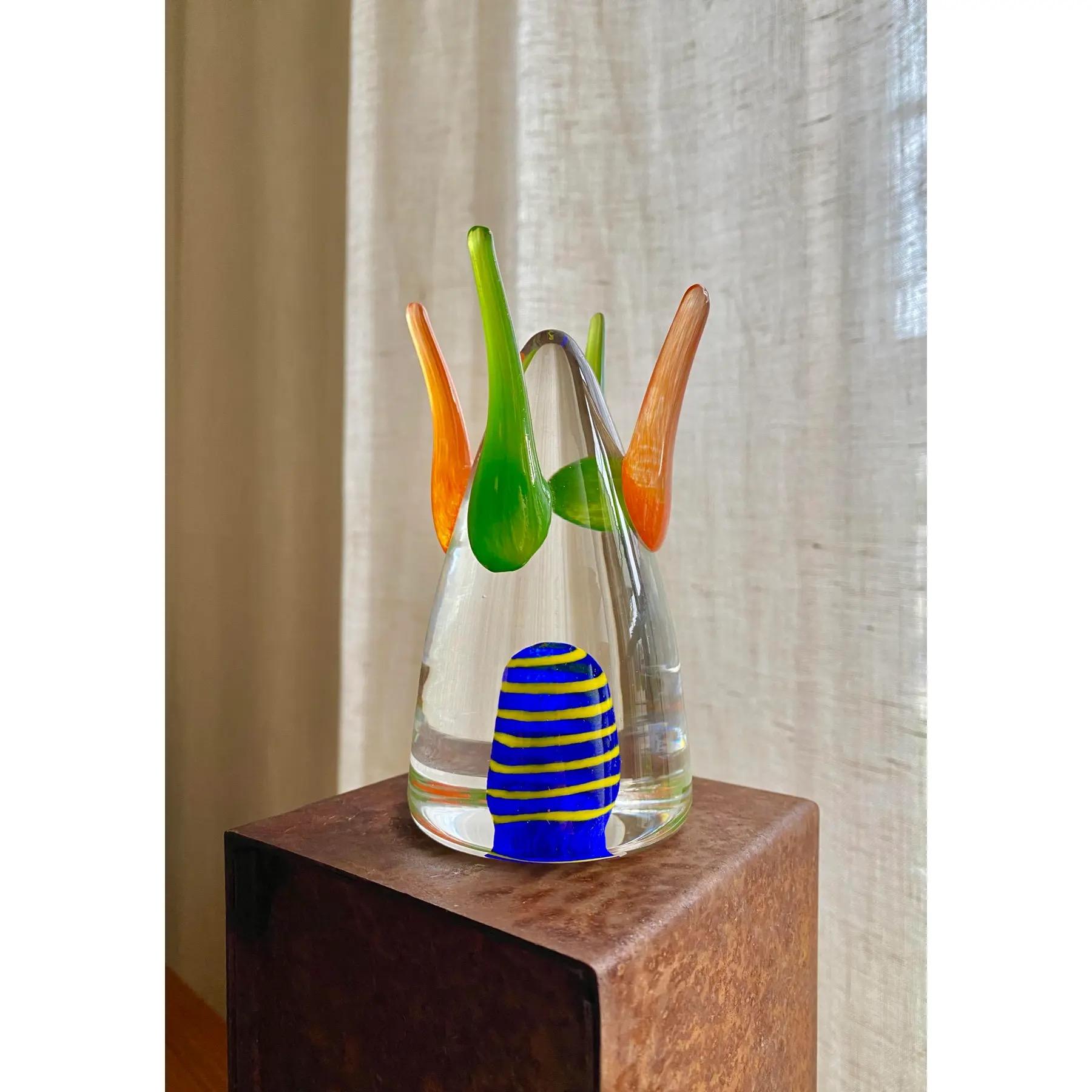 Escultura de vidrio de estudio de Shafaq Malik. Tiene aplicados remates naranjas y verdes con una burbuja flotante de caña azul marino y amarilla en la parte inferior. Está en excelente estado original, sin golpes ni arañazos en el cristal.
