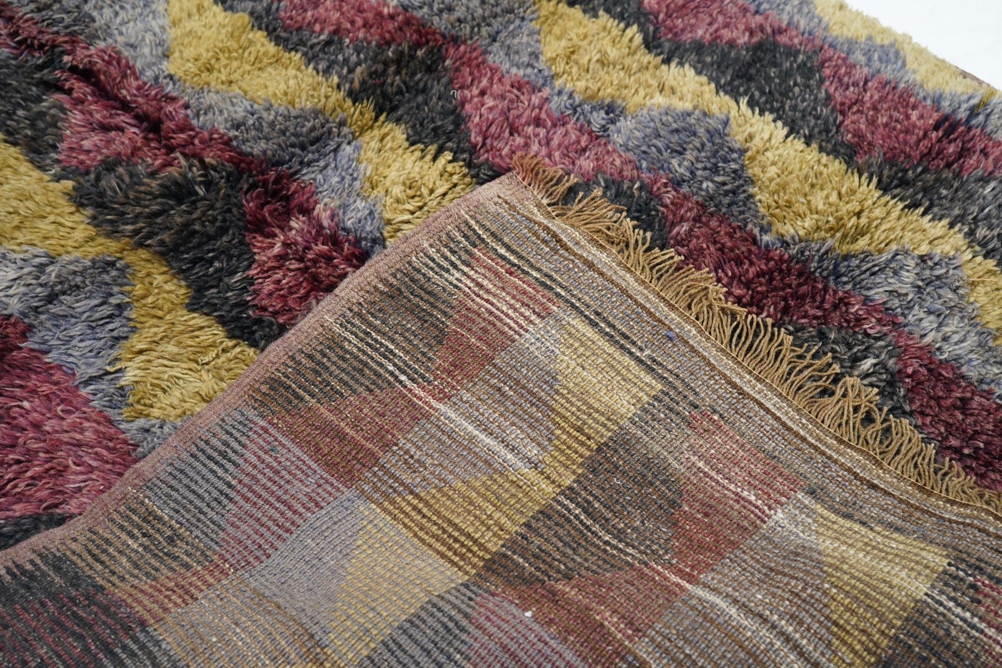 Tappeto Shag 4'6'' x 6'5''. Con un lungo pelo ispido e lanoso in cinque sezioni verticali, in motivi triangolari, nei toni dell'ardesia e del ruggine. Non ci sono bordi, tranne una linea stretta a un'estremità. Trama grossa, base in lana. Maniglia