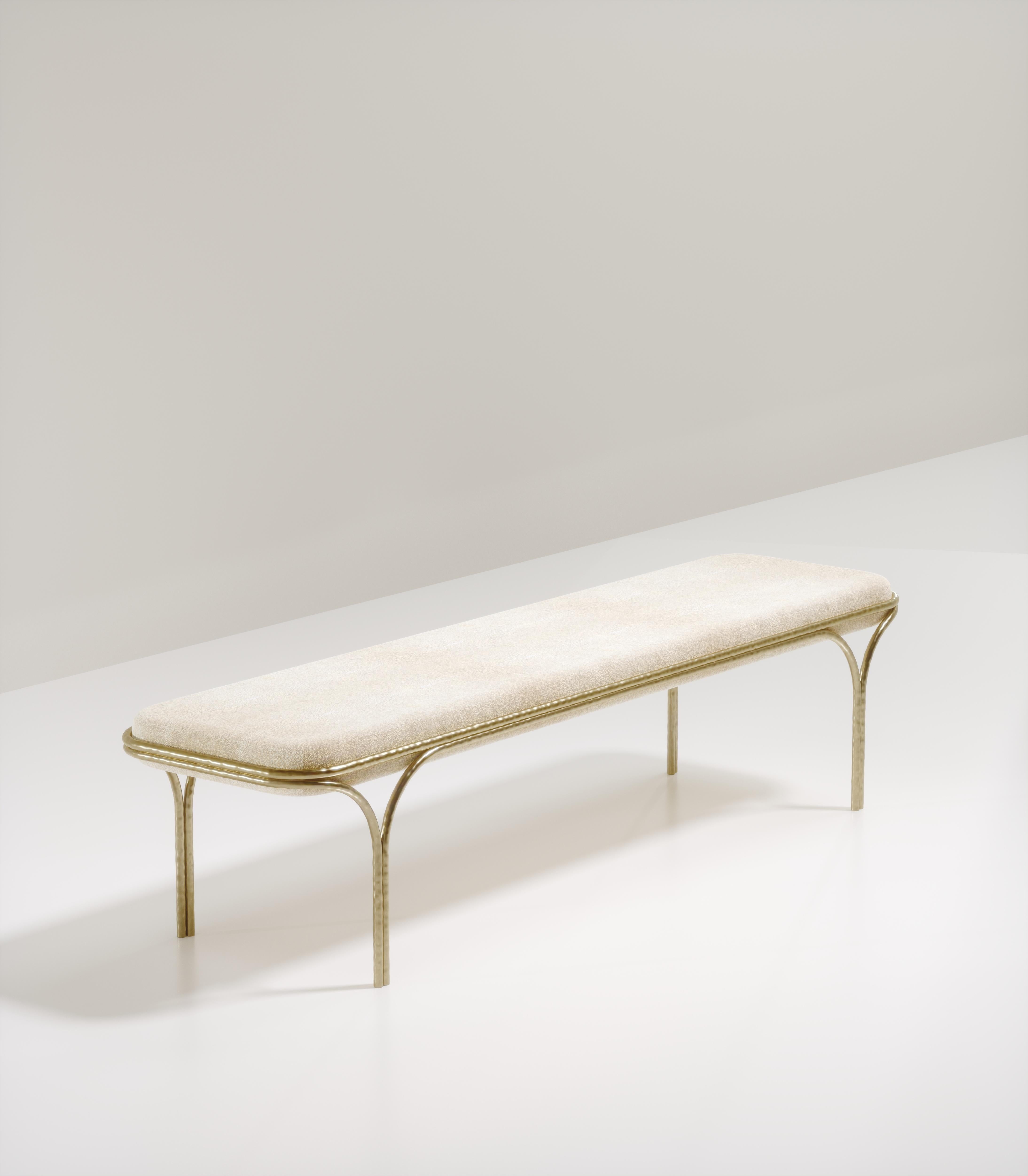 Le banc Arianne de R&Y Augousti est une pièce élégante pour tout espace. L'assise en galuchat crème, aux bords incurvés, repose sur une structure organique en bronze-patine. Le cadre et les pieds complexes ont un effet de 