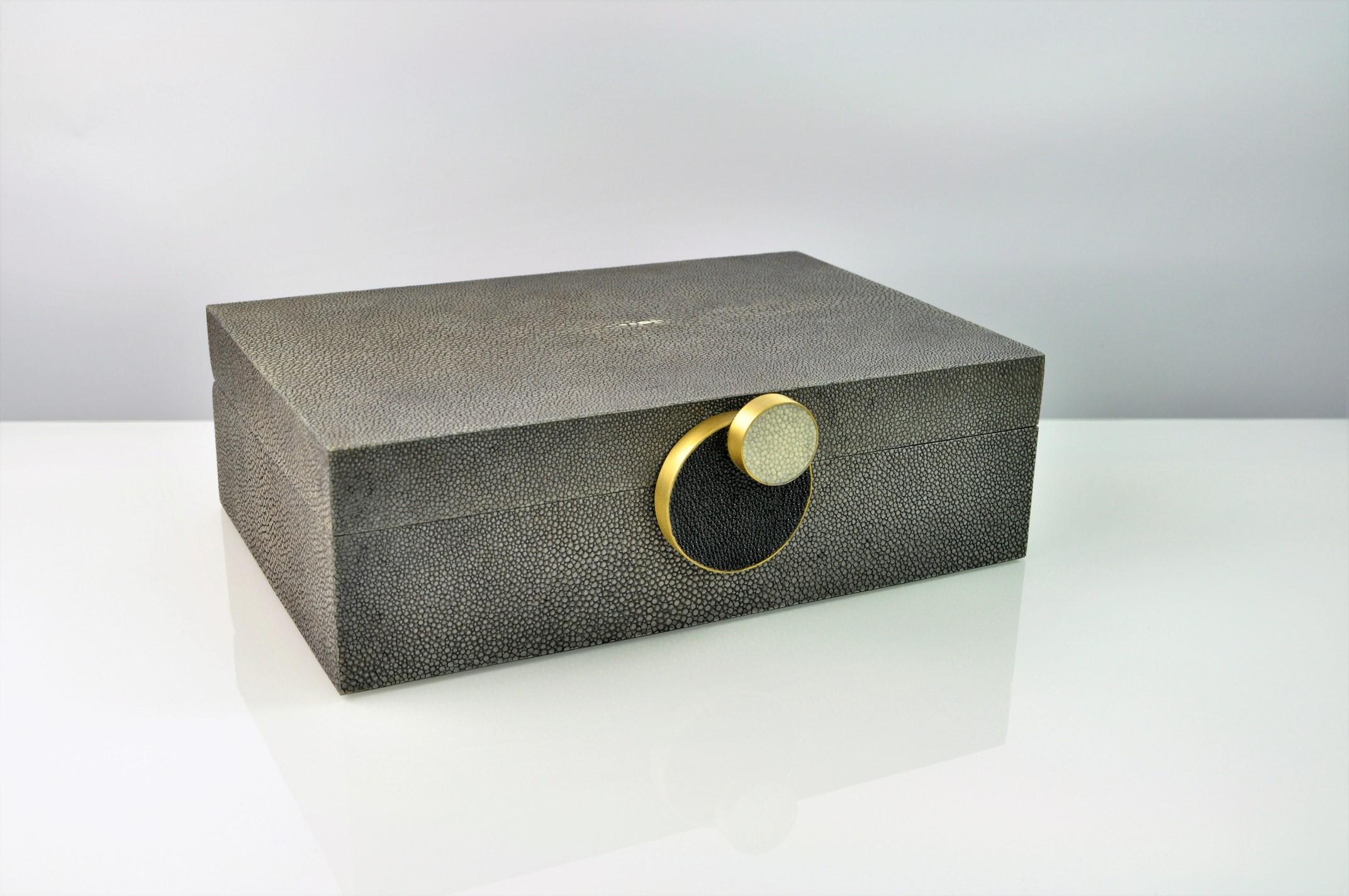 This elegant box Circle (small) is made of shagreen with a beautiful circular decor with brass trims on the front.
The box is hinged with a black microsuede interior.

Perfect to tidy up your remote controls on your coffee table, or your precious