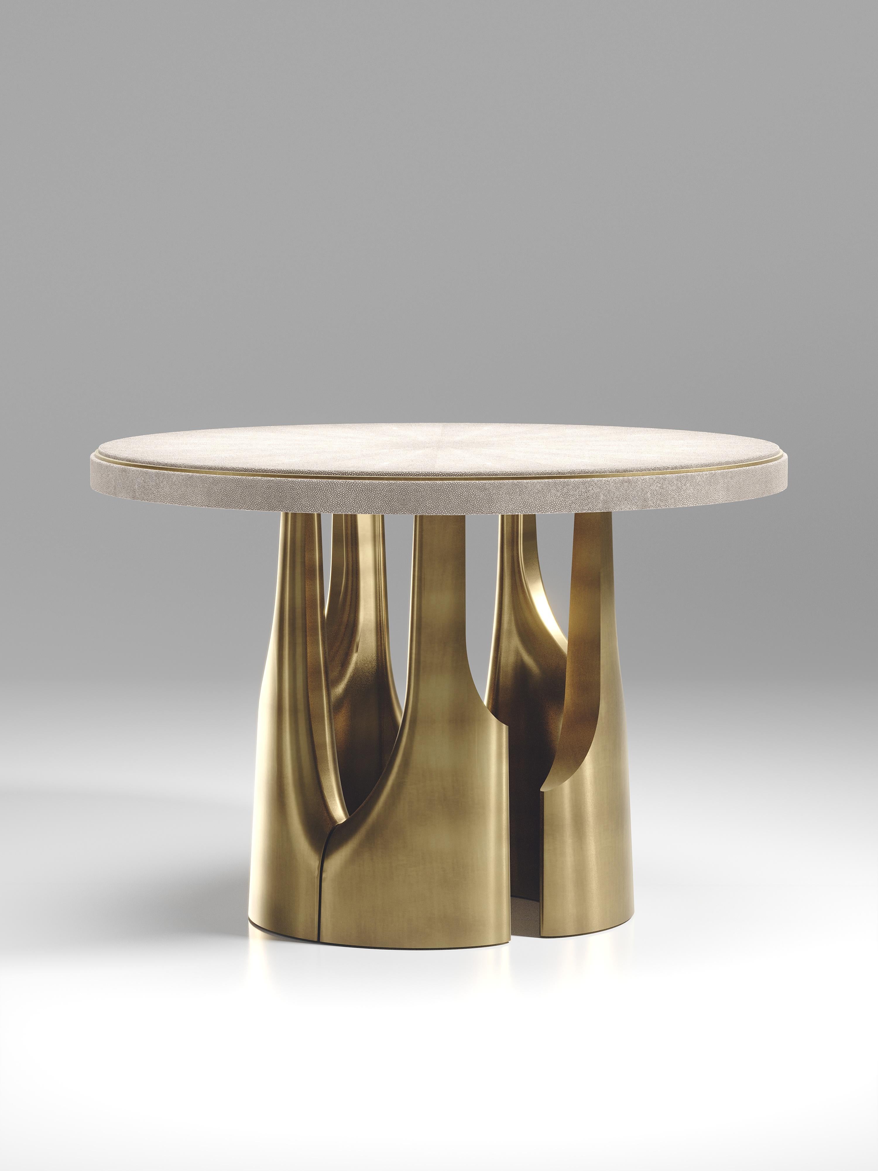 The triptych breakfast table by R&Y Augousti is a stunning multi-faceted sculptural piece. The beautiful hand craved details on the bronze-patina base demonstrate the incredible artisan work of Augousti. The top is inlaid in cream shagreen.