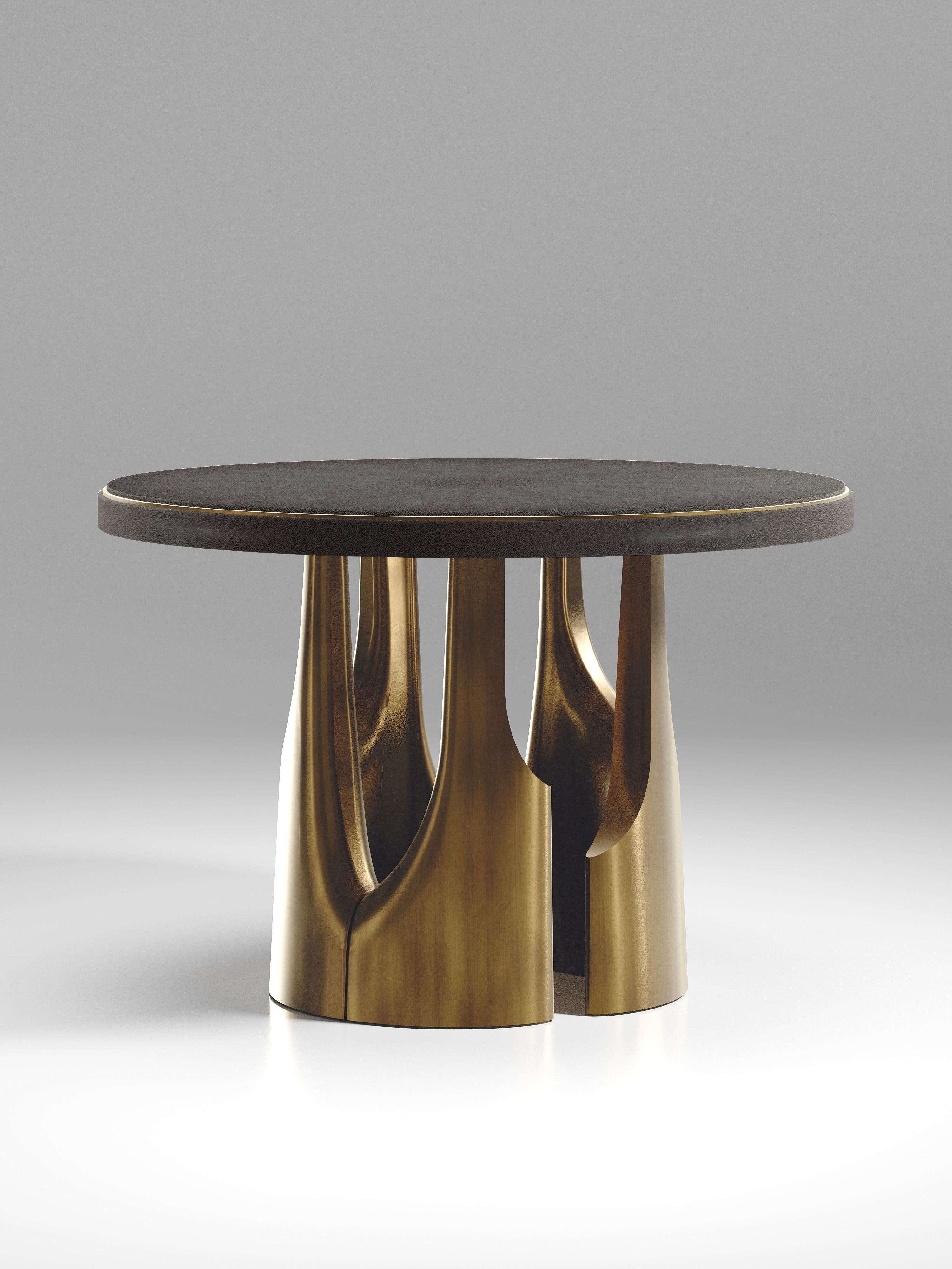 The triptych breakfast table by R&Y Augousti is a stunning multi-faceted sculptural piece. The beautiful hand craved details on the bronze-patina base demonstrate the incredible artisan work of Augousti. The top is inlaid in black shagreen.