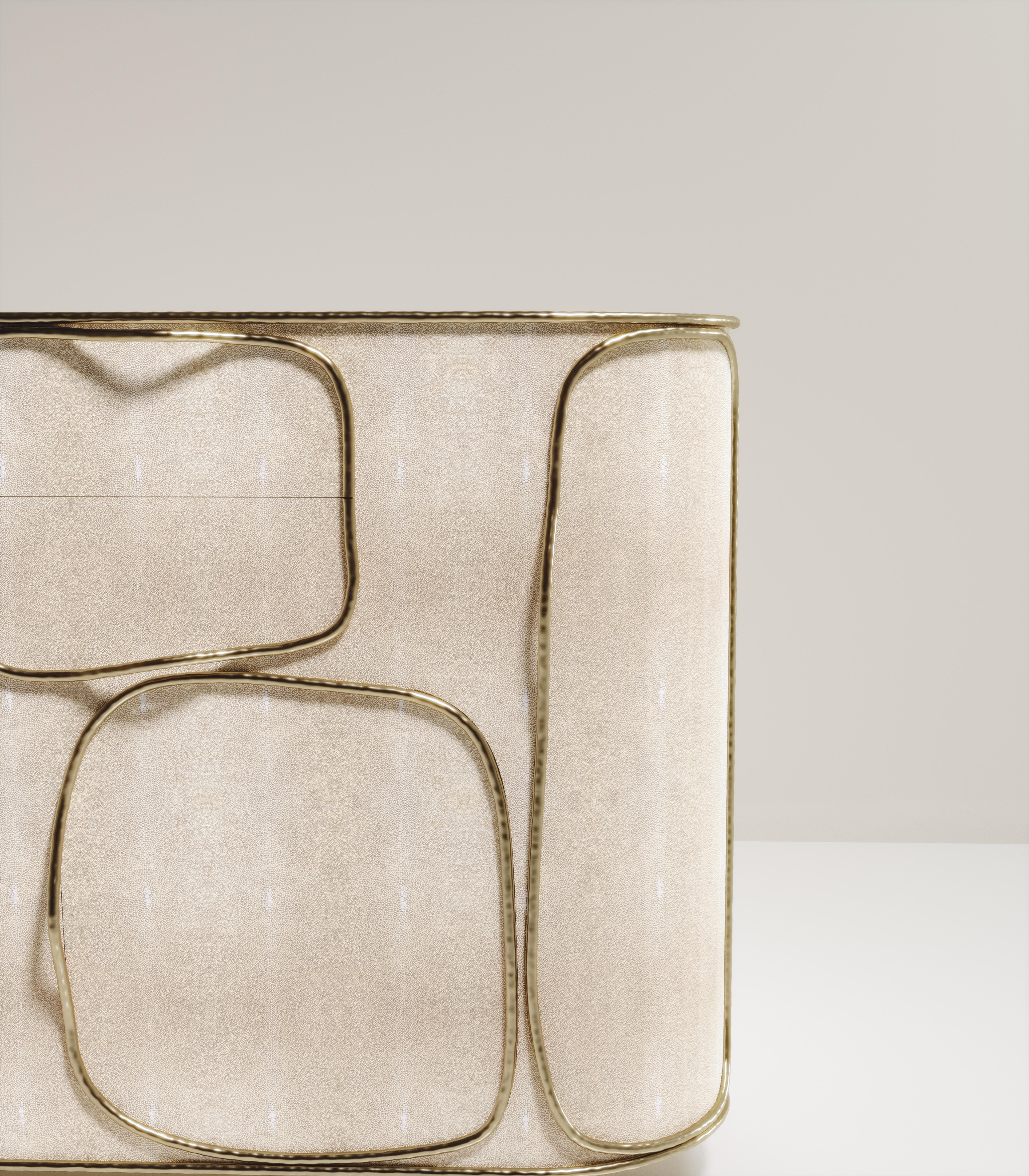 El bufé Arianne de R & Y Augousti es una pieza única. La pieza en su conjunto presenta incrustaciones de shagreen crema acentuadas con intrincados detalles de latón bronce-patina que tienen el característico efecto de 