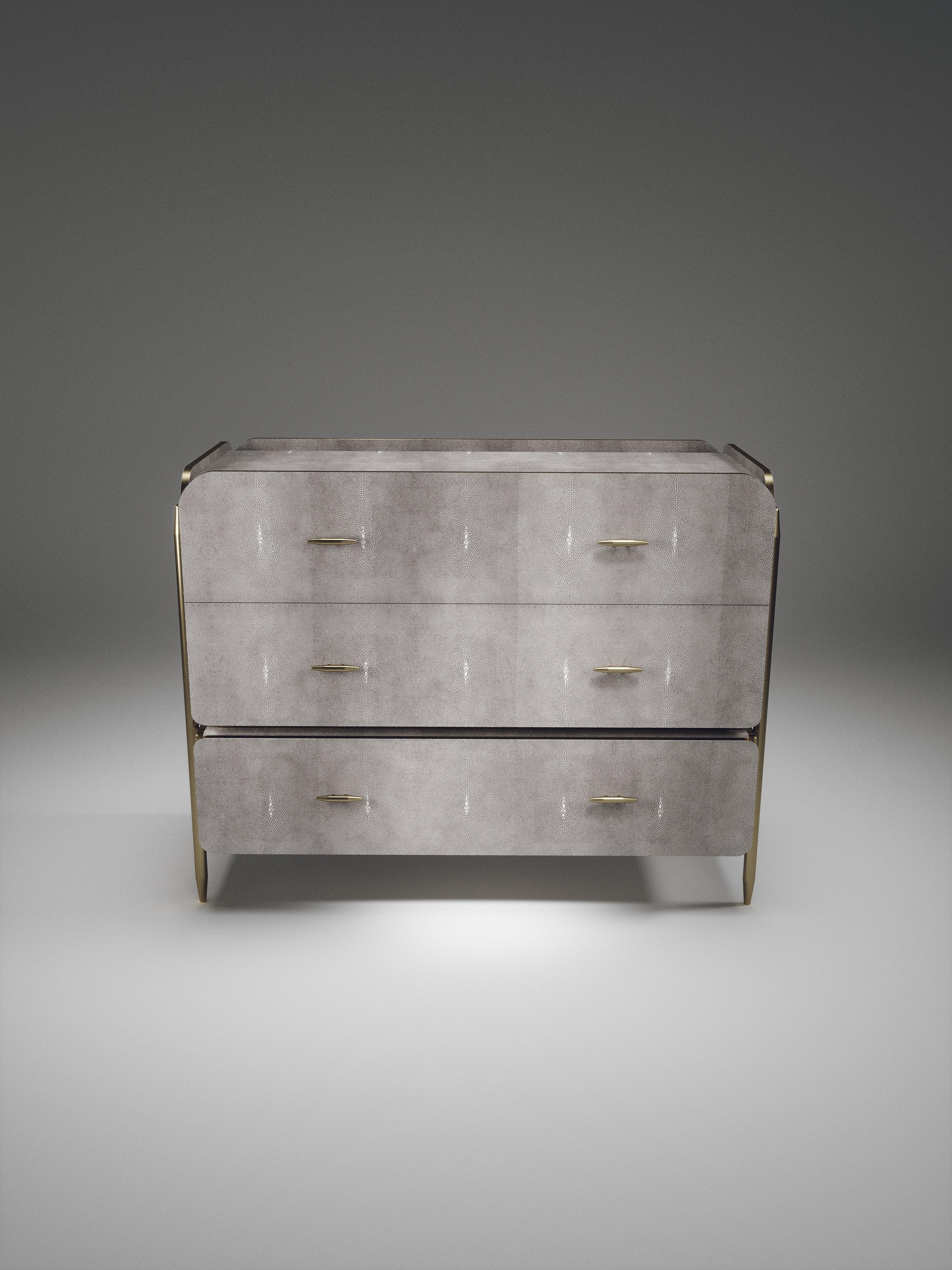 The Dandy Rectangle Chest of Drawers by Kifu Paris is an elegant and a luxurious home accent, inlaid in light grey shagreen with bronze-patina brass details. This piece includes 3 drawers total and the interiors are inlaid in gemelina wood veneer.
