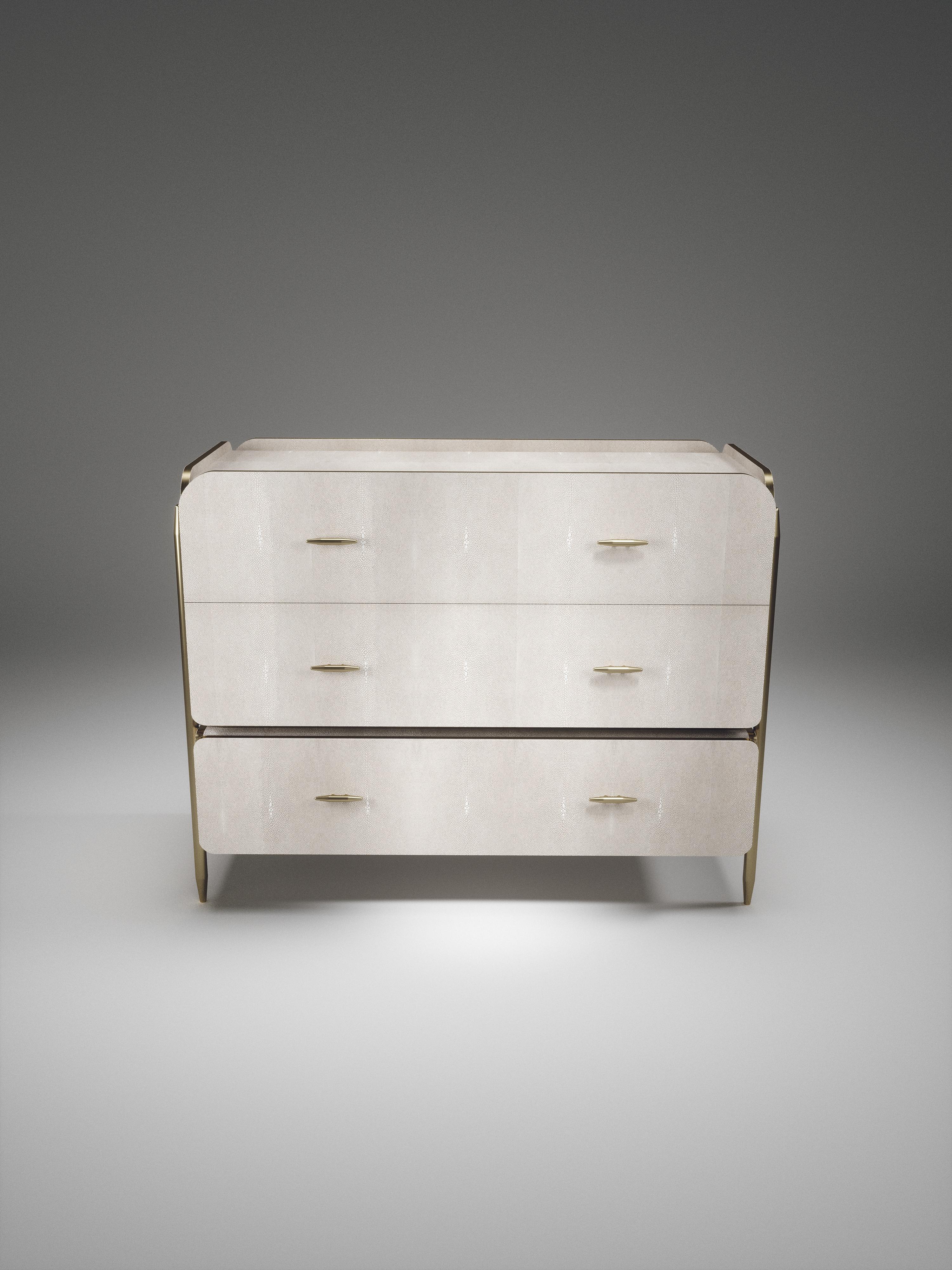 The Dandy Rectangle Chest of Drawers by Kifu Paris is an elegant and a luxurious home accent, inlaid in cream shagreen with bronze-patina brass details. This piece includes 3 drawers total and the interiors are inlaid in gemelina wood veneer. The
