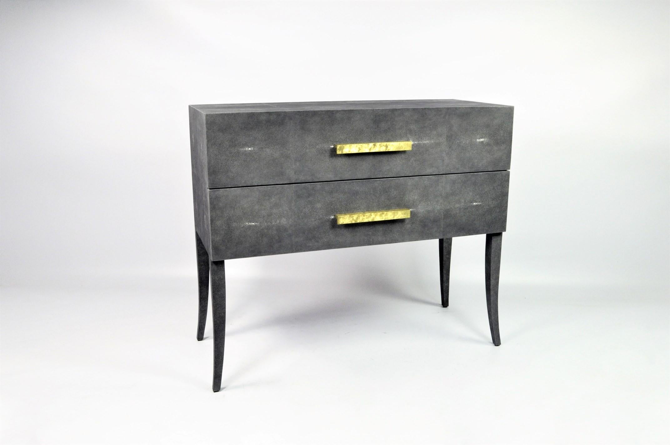 This chest of drawers is made of dark grey shagreen (our ref CARBON).
It has 2 drawers with large brass handles. The brass has been hammered by hand to give an irregular and artistic finish aspect.
The interior is made with a dark wood veneer.

