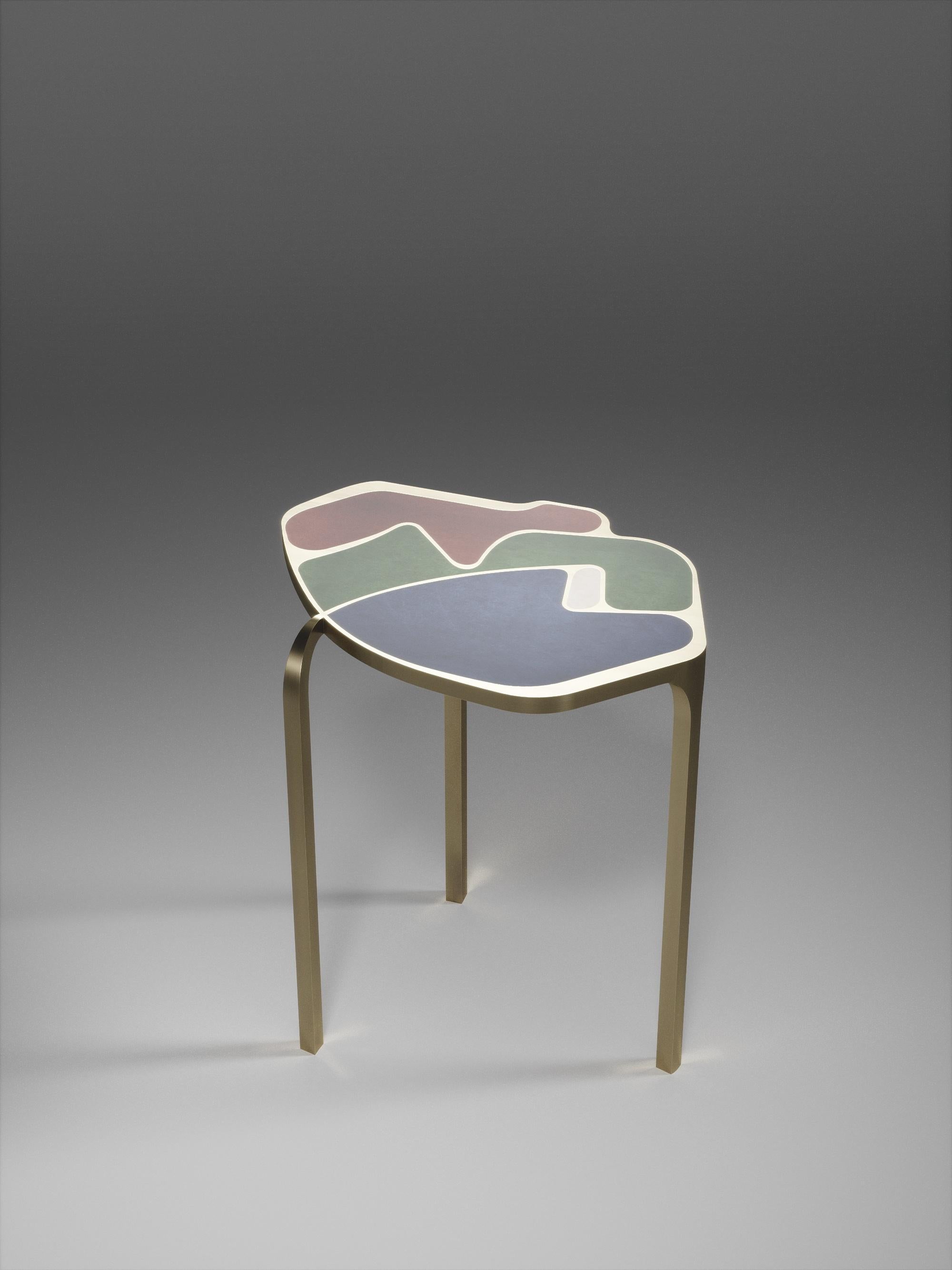La table d'appoint Cocteau de R&Y Augousti est une pièce unique en son genre. Cette pièce sculpturale et éthérée comporte des formes abstraites et des figures que l'on peut interpréter de différentes manières. Les inserts en laiton bronze-patiné