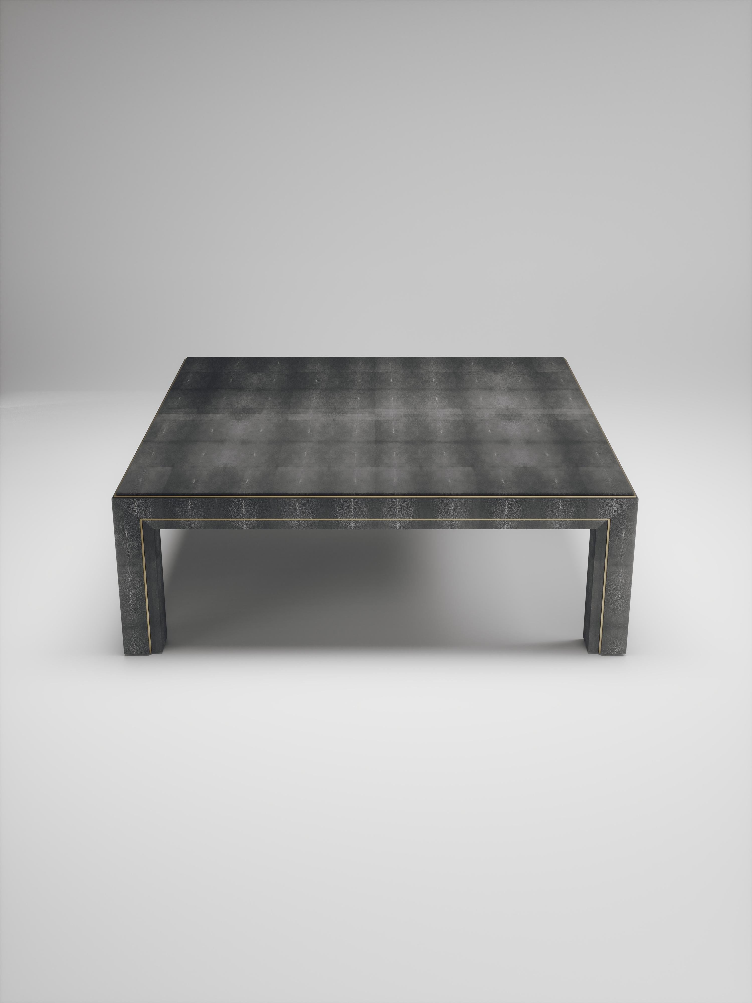 The parsons coffee table by R&Y Augousti is classic and elegant staple piece for your home. The clean lines of the overall piece, inlaid in coal black shagreen, are accentuated by the discreet bronze-patina brass indentation detail giving it a