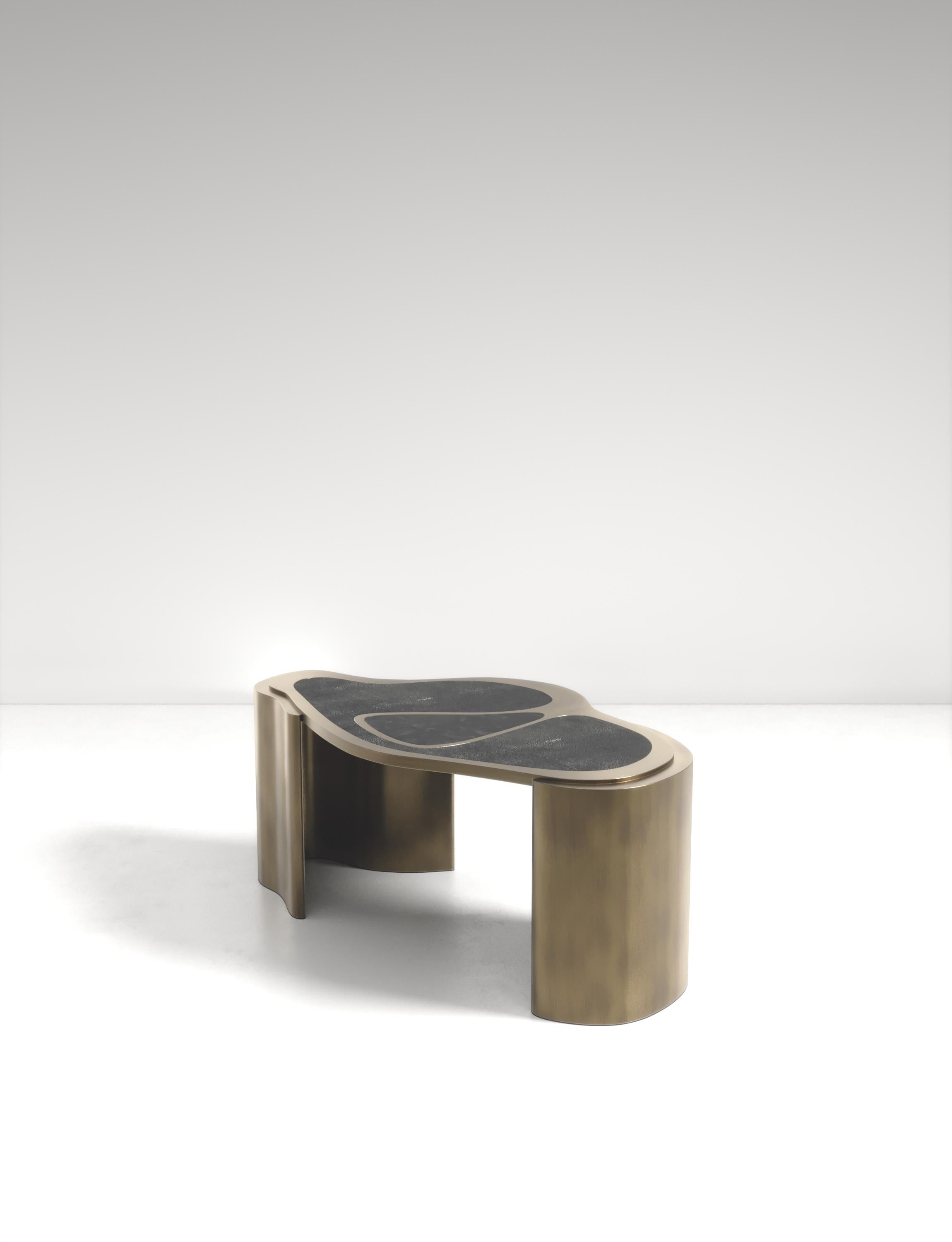 La table basse Mask de Kifu Paris est une pièce polyvalente et organique. Le plateau et la base amorphes sont incrustés d'un mélange de galuchat noir de charbon, de coquille de stylo noire et de laiton bronze-patine. Cette pièce a été conçue par