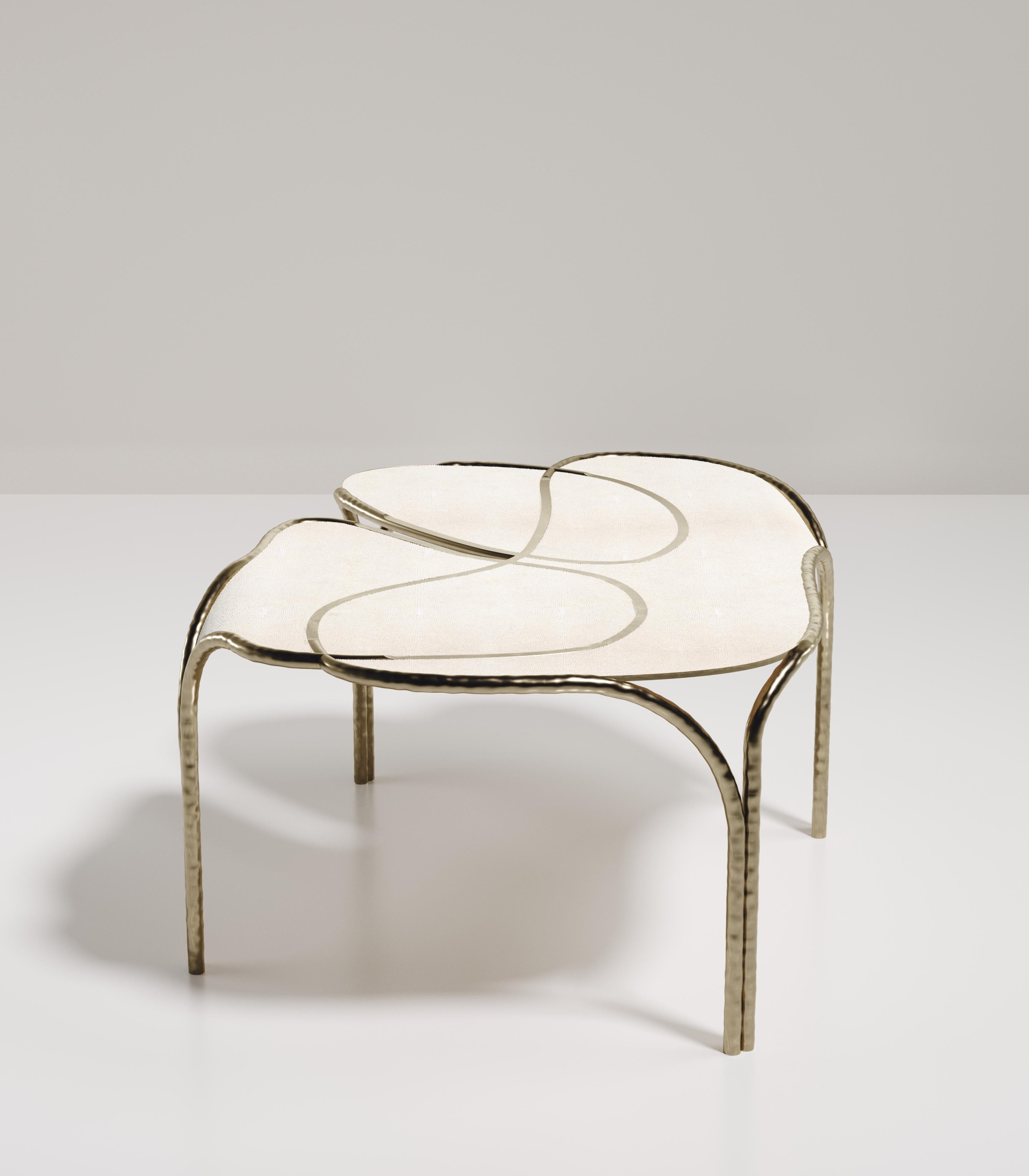 The Arianne Coffee Table by R&Y Augousti is one of a kind statement and whimsical piece. The overall piece is inlaid in cream shagreen accentuated with intricate bronze-patina brass details that have the signature Augousti 
