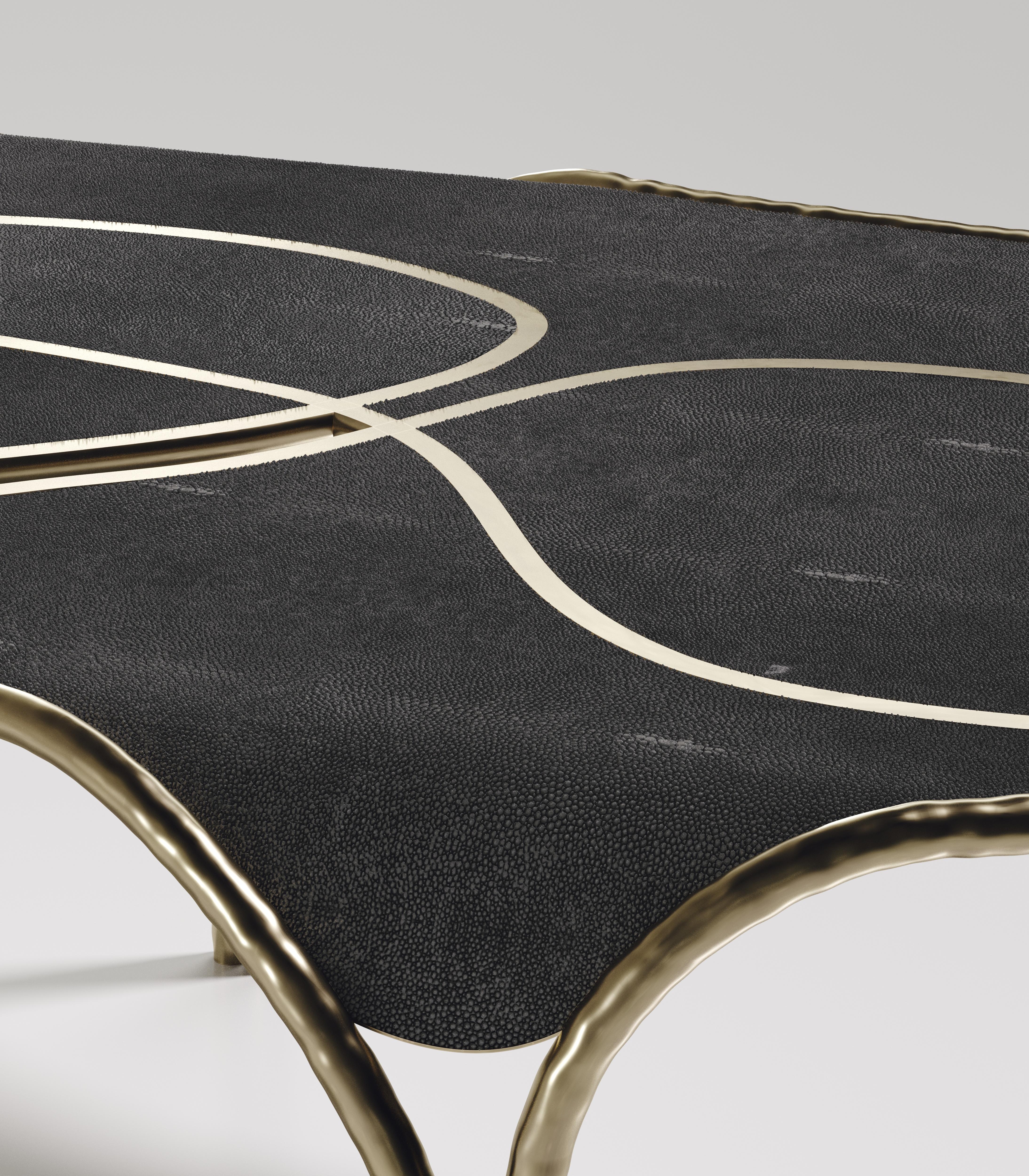 The Arianne coffee table by R&Y Augousti is one of a kind statement and whimsical piece. The overall piece is inlaid in coal black shagreen accentuated with intricate bronze-patina brass details that have the signature Augousti 
