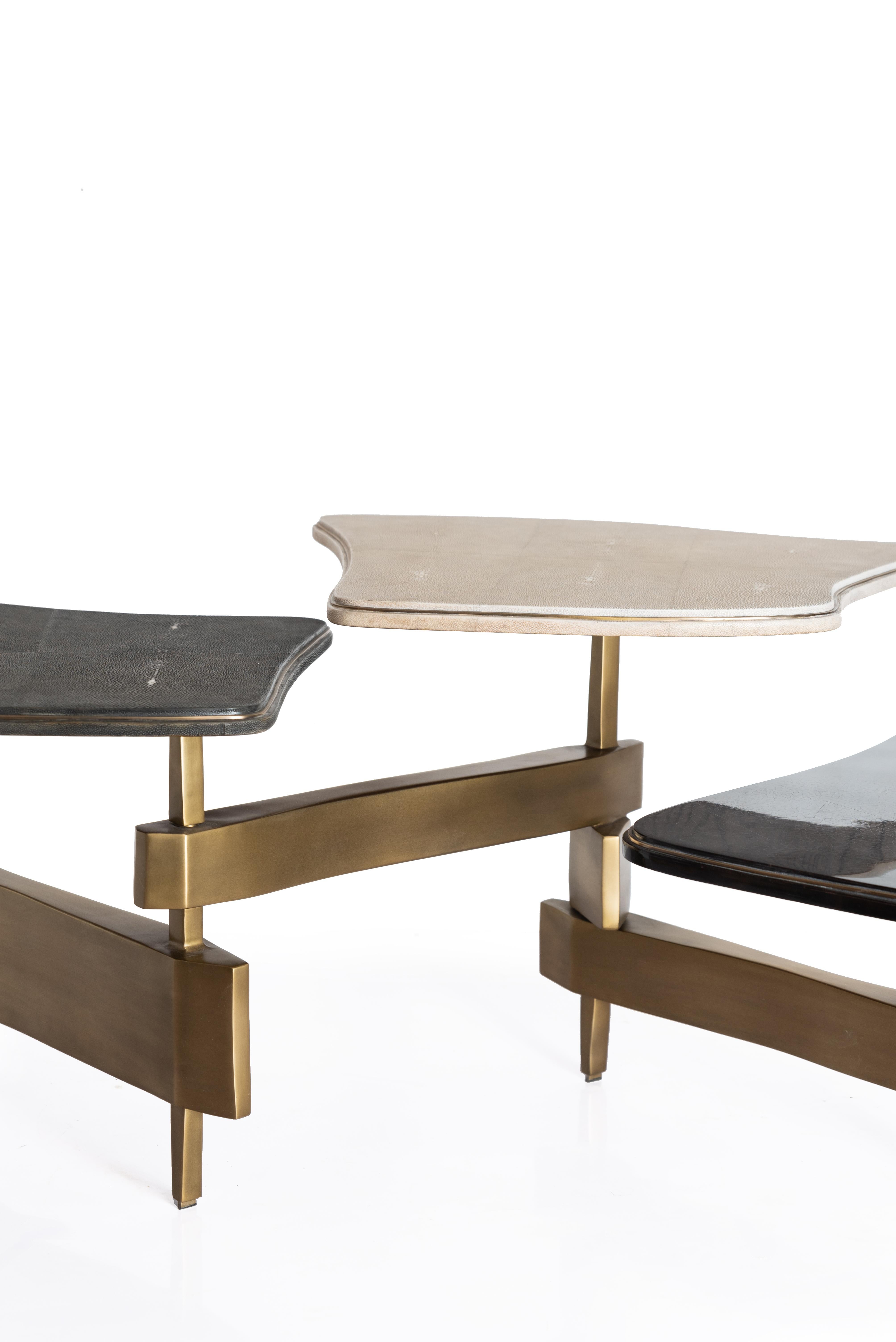 The Metropolis 3-top coffee table by Kifu Paris is a dramatic and sculptural design that demonstrates the incredible and signature artisanale work from her Augousti genes. The bronze-patina brass base of the coffee table is conceptually inspired by