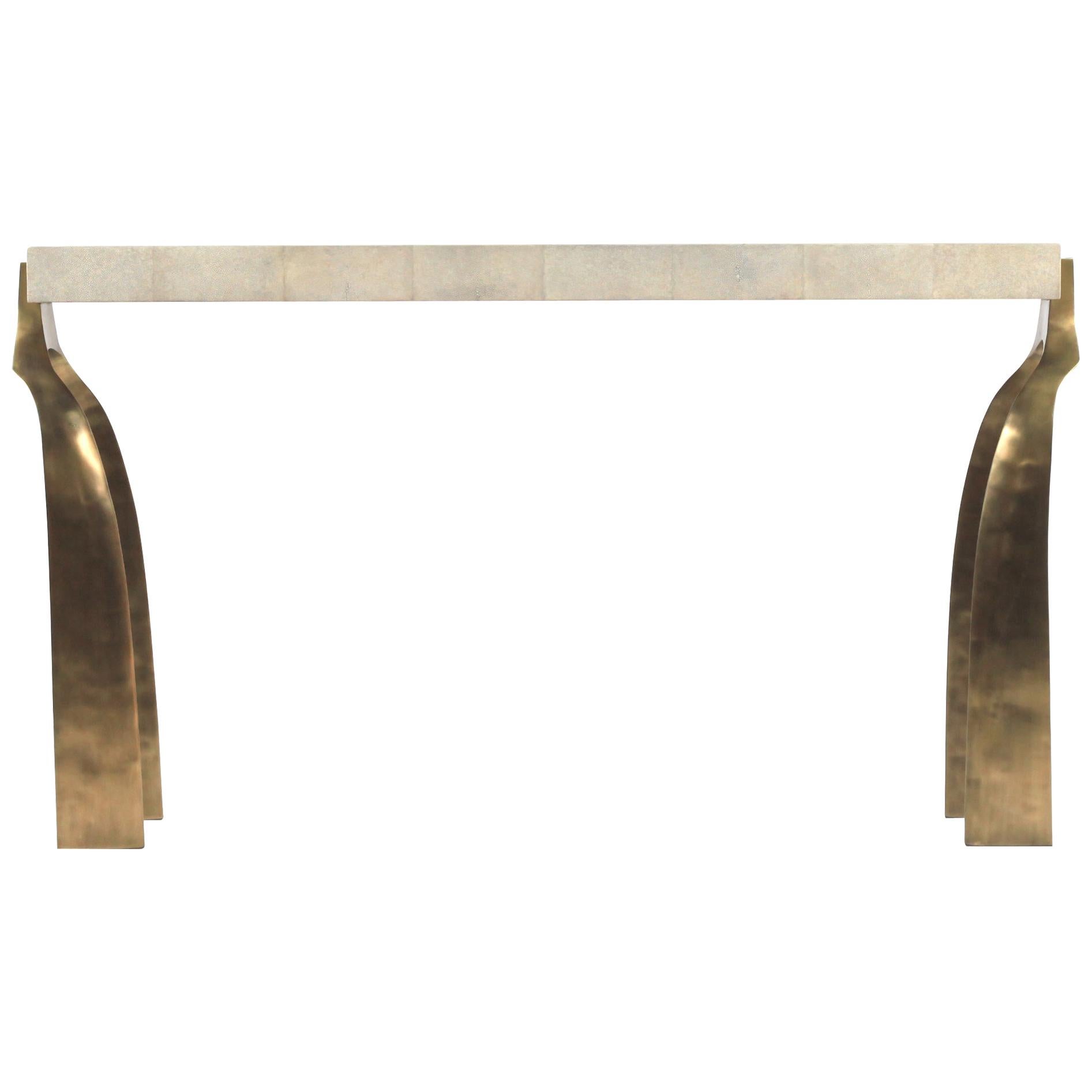 The Galaxy console table is both dramatic and organic it’s unique design. The cream shagreen inlaid top sits on a pair of ethereal and sculptural bronze-patina brass legs. This console table also comes in a writing desk version, see image at end of