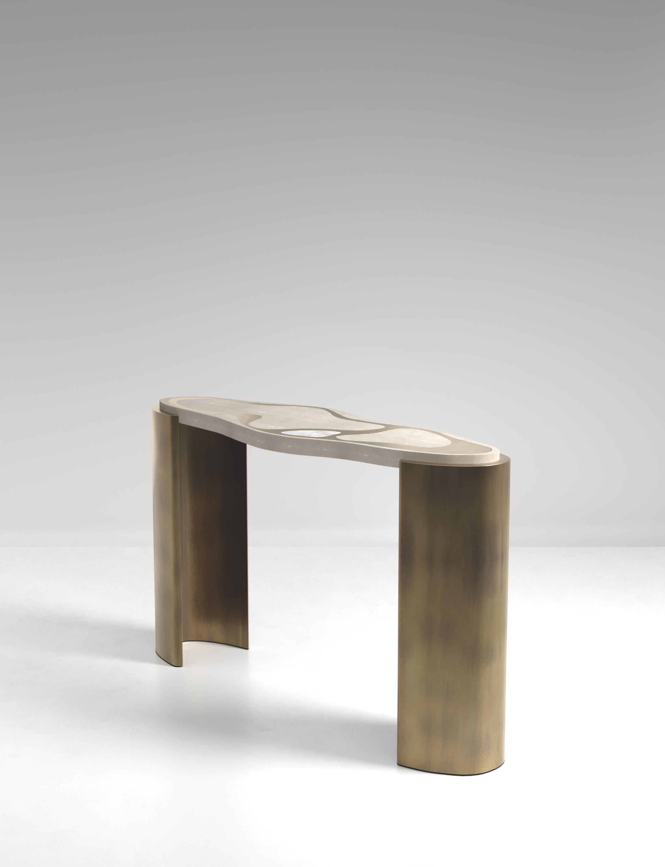 The Mask Console Table by Kifu Paris is a versatile and organic piece. The amorphous top and base are inlaid in a mixture of cream shagreen, white quartz and bronze-patina brass. This piece is designed by Kifu Augousti the daughter of Ria and Yiouri