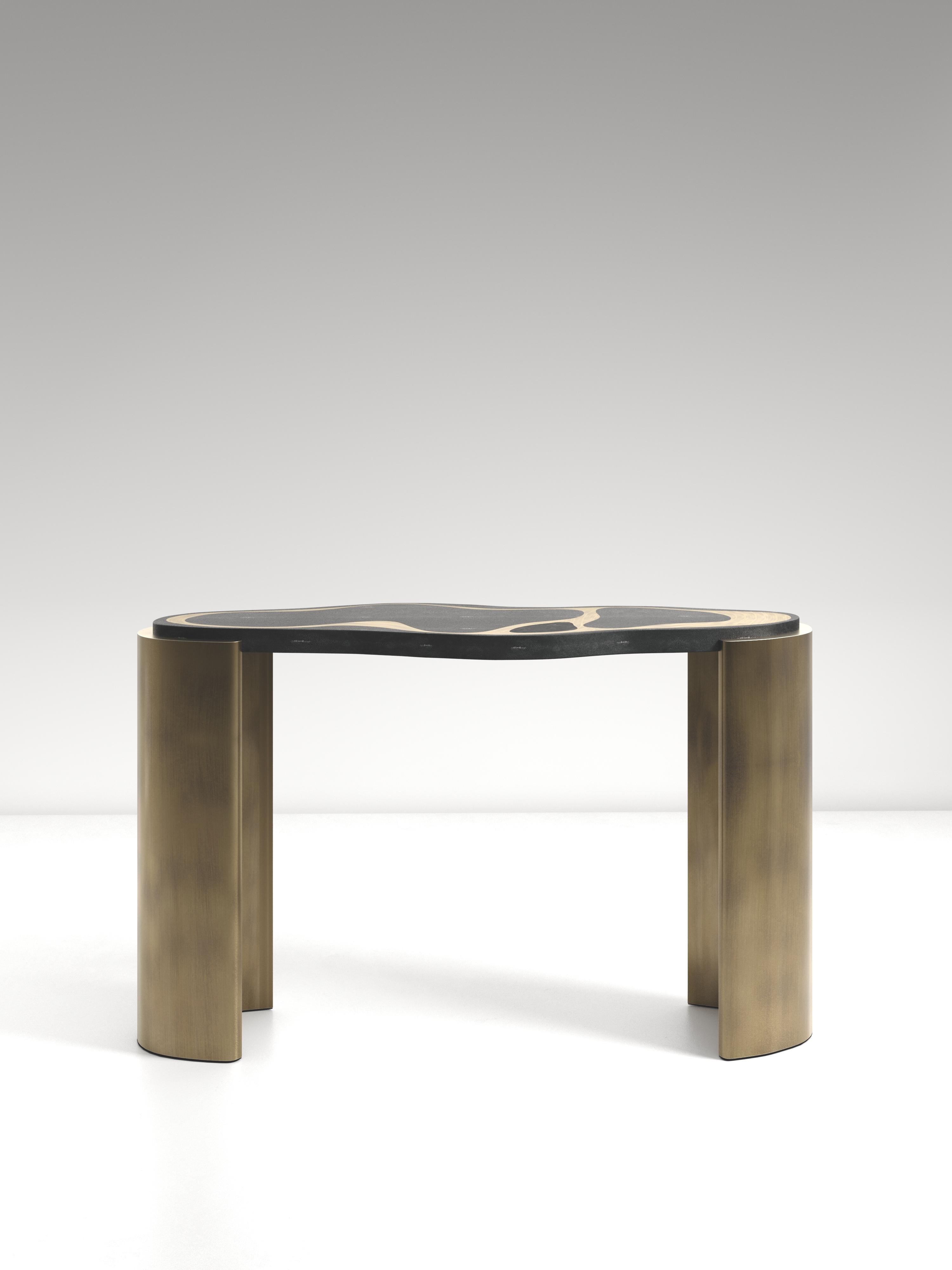 The Mask Console Table by Kifu Paris is a versatile and organic piece. The amorphous top and base are inlaid in a mixture of coal black shagreen, black pen shell and bronze-patina brass. This piece is designed by Kifu Augousti the daughter of Ria