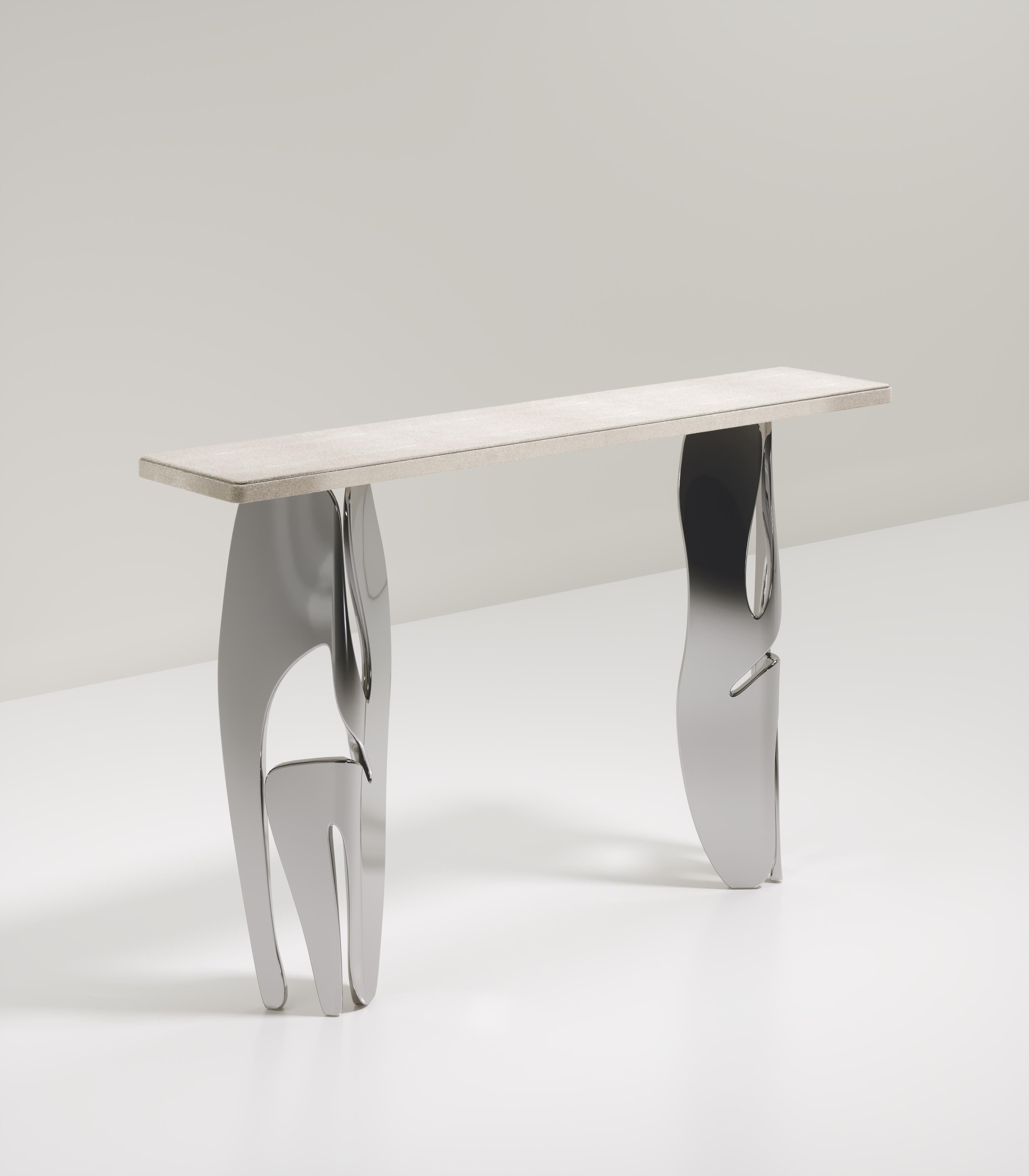 The Metropolis II console by R&Y Augousti is a statement piece. The cream shagreen inlaid top sits on a pair of dramatic sculptural chrome finish polished stainless steel legs, showcasing the brand's incredible artisanal work. The top has a discreet