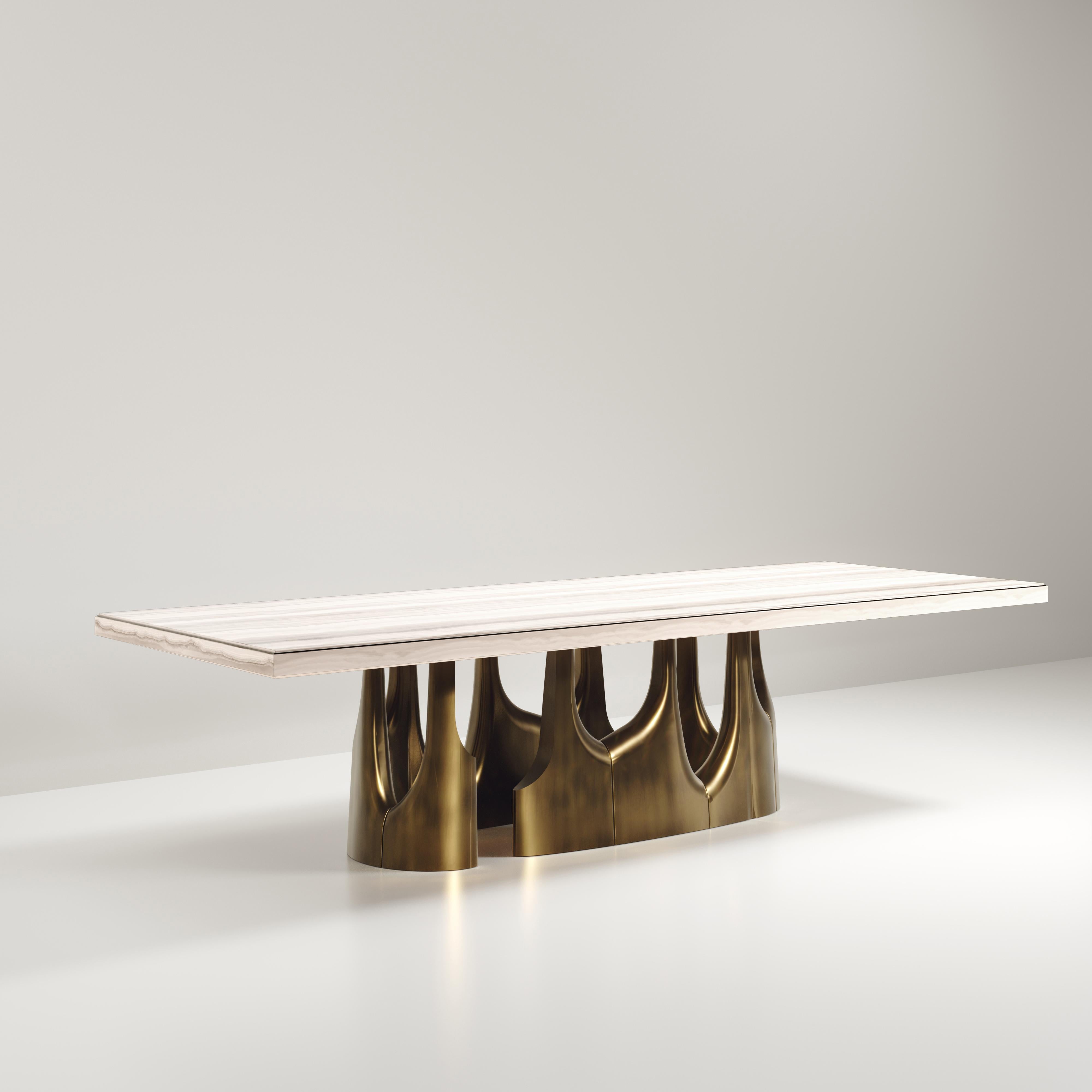 The Triptych II dining table by R&Y Augousti is a stunning multi-faceted sculptural piece. The beautiful hand craved details on the long clustered bronze-patina base demonstrate the incredible artisan work of Augousti. The top is a rich cream onyx.