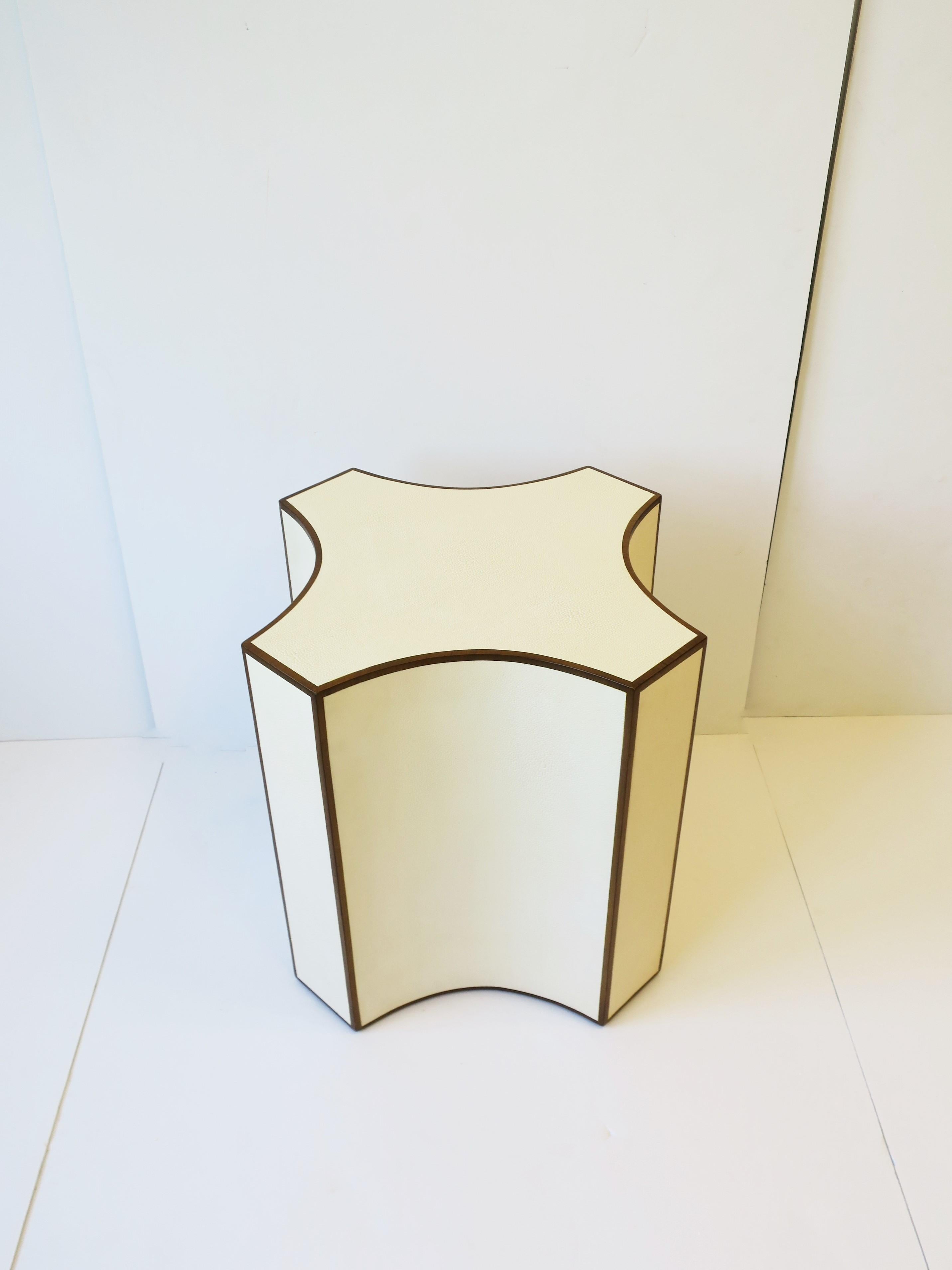A beautiful geometric shagreen-esque (faux shagreen) pedestal side or drinks table in an off-white or cream hue complimented with a thin rich brown wood edge design. Table can be positioned two ways as show in images. 

Table measures: 16