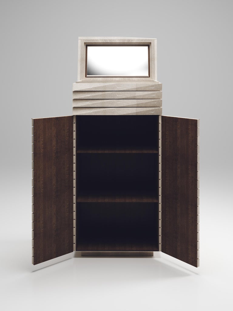 The fluted bar cabinet by R & Y Augousti is a sleek and geometric design. The cream shagreen inlaid piece provides great utility while retaining a striking aesthetic with the incredible hand craved fluted details. This piece can be used as a bar
