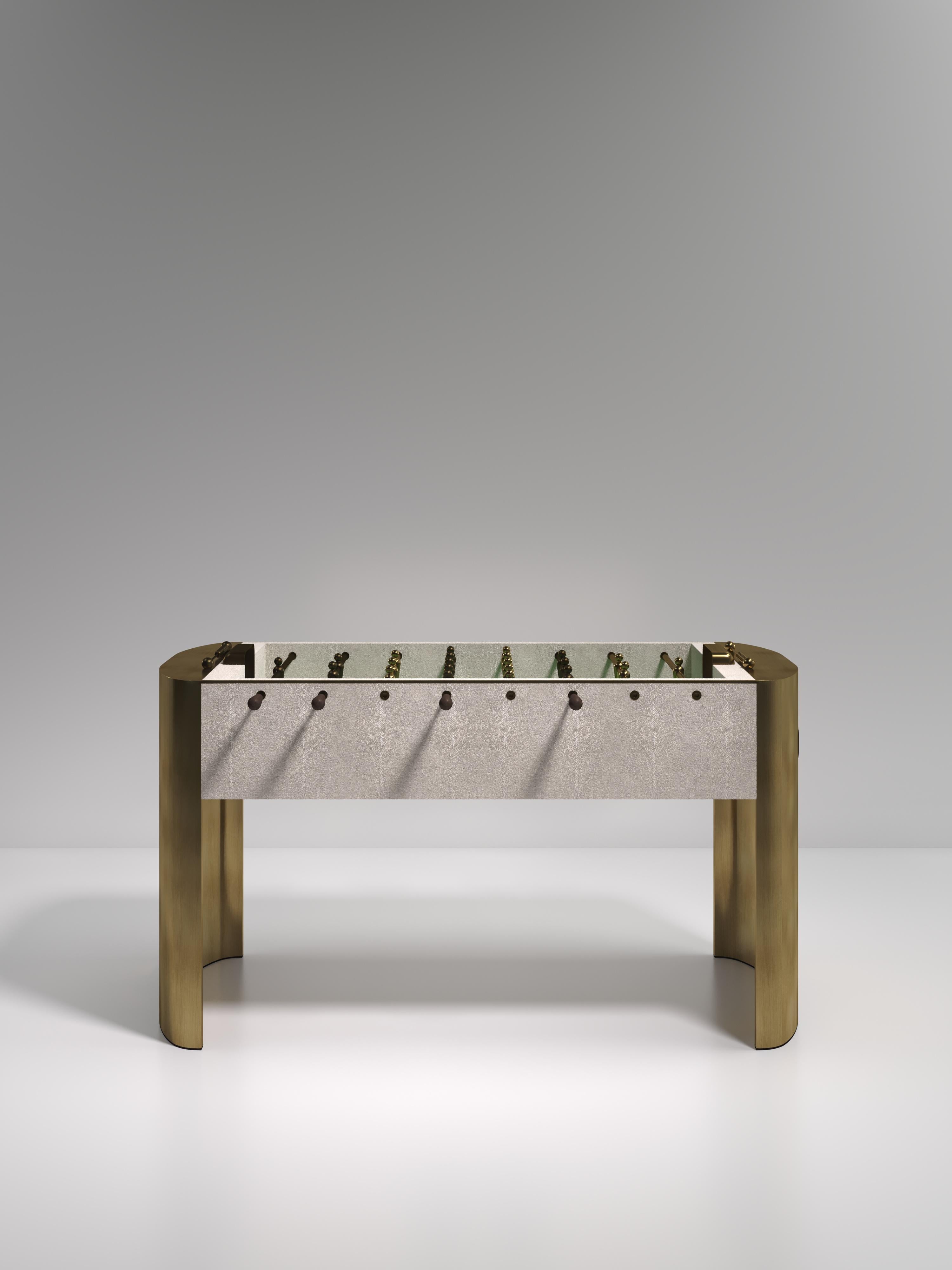 El futbolín Ellipse de R & Y Augousti es una pieza realmente lujosa para tu hogar. La parte central de juego de piel de raya color crema está encajada entre unas impresionantes patas curvadas de latón bronce-patino, creando la mesa de juego de lujo