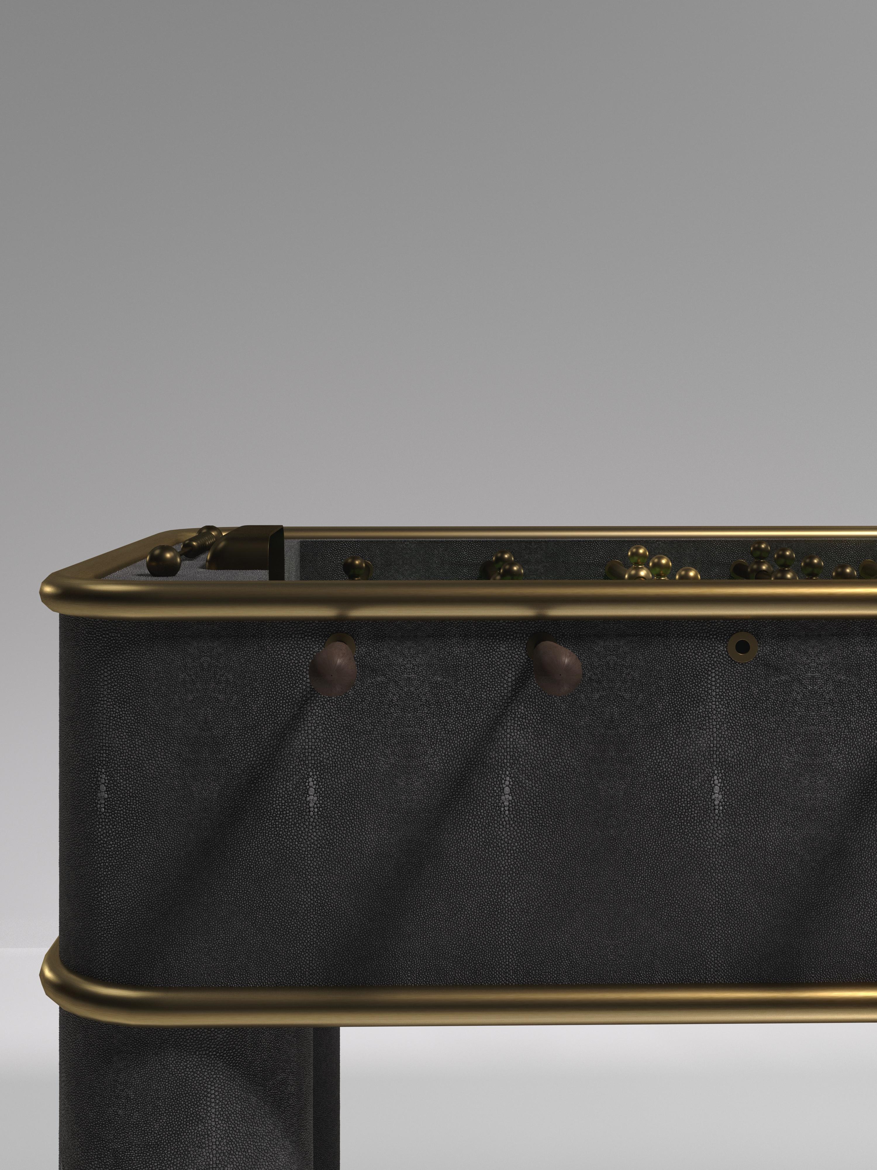 El futbolín Ring de R & Y Augousti es una pieza de lujo para tu hogar. Las líneas limpias de toda la pieza en piel de raya negra, acentuadas por el elegante detalle de los ribetes de latón bronce-patino, la convierten en la mesa de juego de lujo