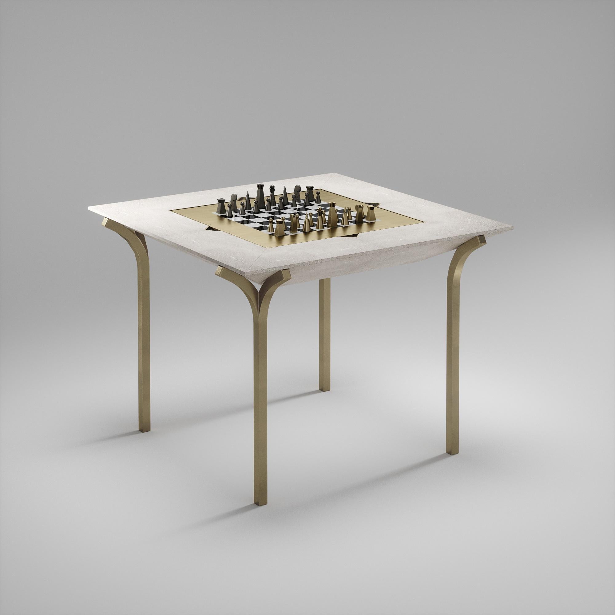 La table de jeu 4 en 1 Marcel R&Y Augousti est une véritable pièce de luxe pour votre maison. Les lignes épurées de l'ensemble de la pièce en galuchat crème, accentuées par les pieds sculpturaux et élégants en laiton bronze-patina, la rendent