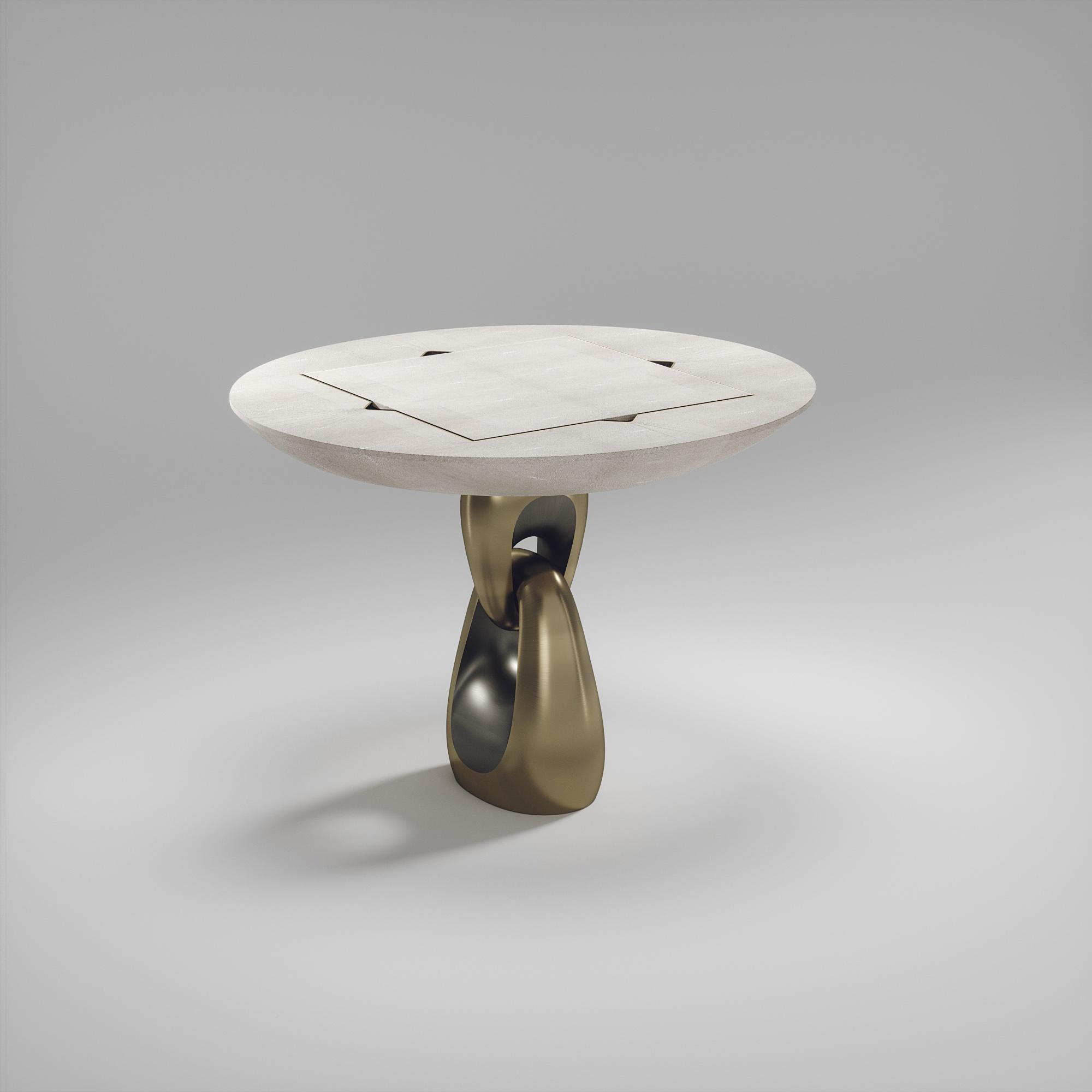 La table de jeu 4 en 1 Saturn de R&Y Augousti est une pièce luxueuse pour votre maison. Les lignes épurées de l'ensemble de la pièce en galuchat crème, accentuées par la base sculpturale et élégante en laiton bronze-patine, la rendent polyvalente