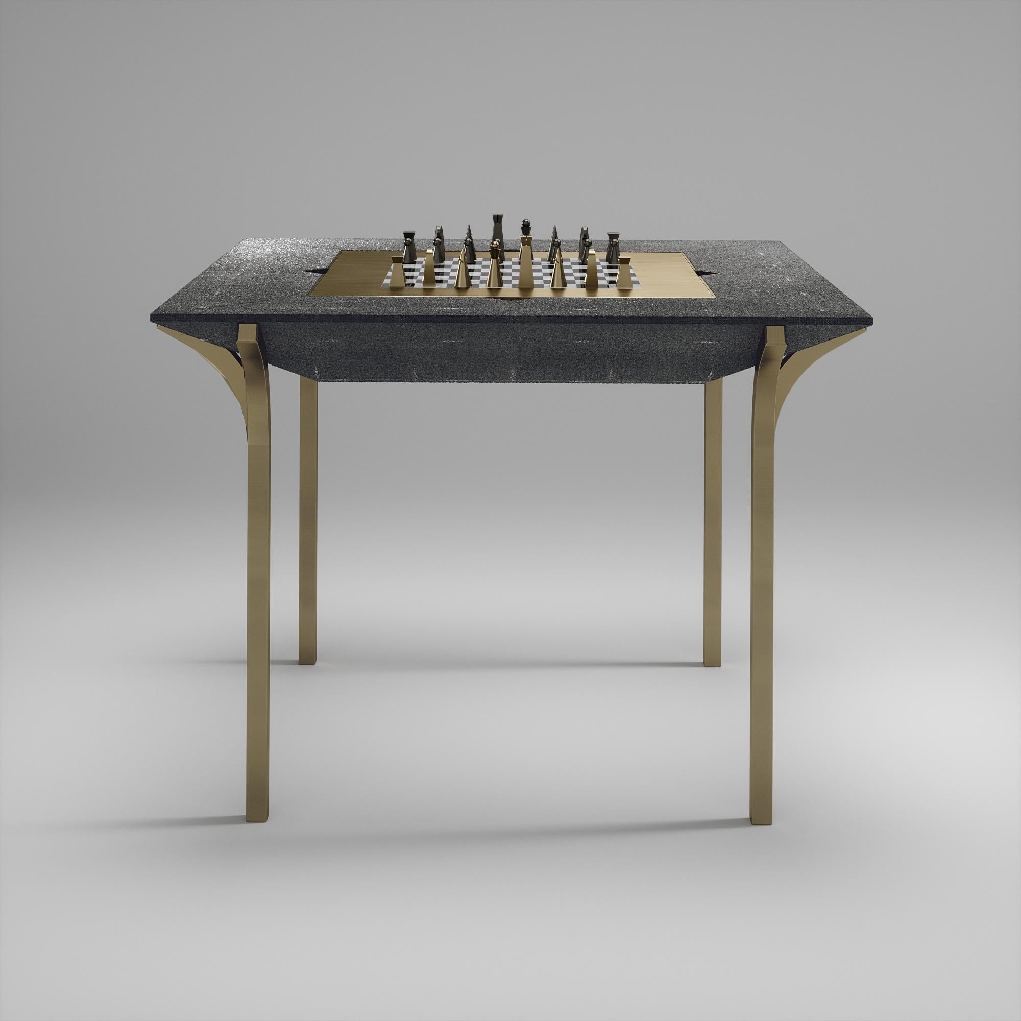 La table de jeu 4 en 1 Marcel R&Y Augousti est une véritable pièce de luxe pour votre maison. Les lignes épurées de l'ensemble du meuble en galuchat noir, accentuées par les pieds sculpturaux et élégants en laiton patiné, en font un meuble