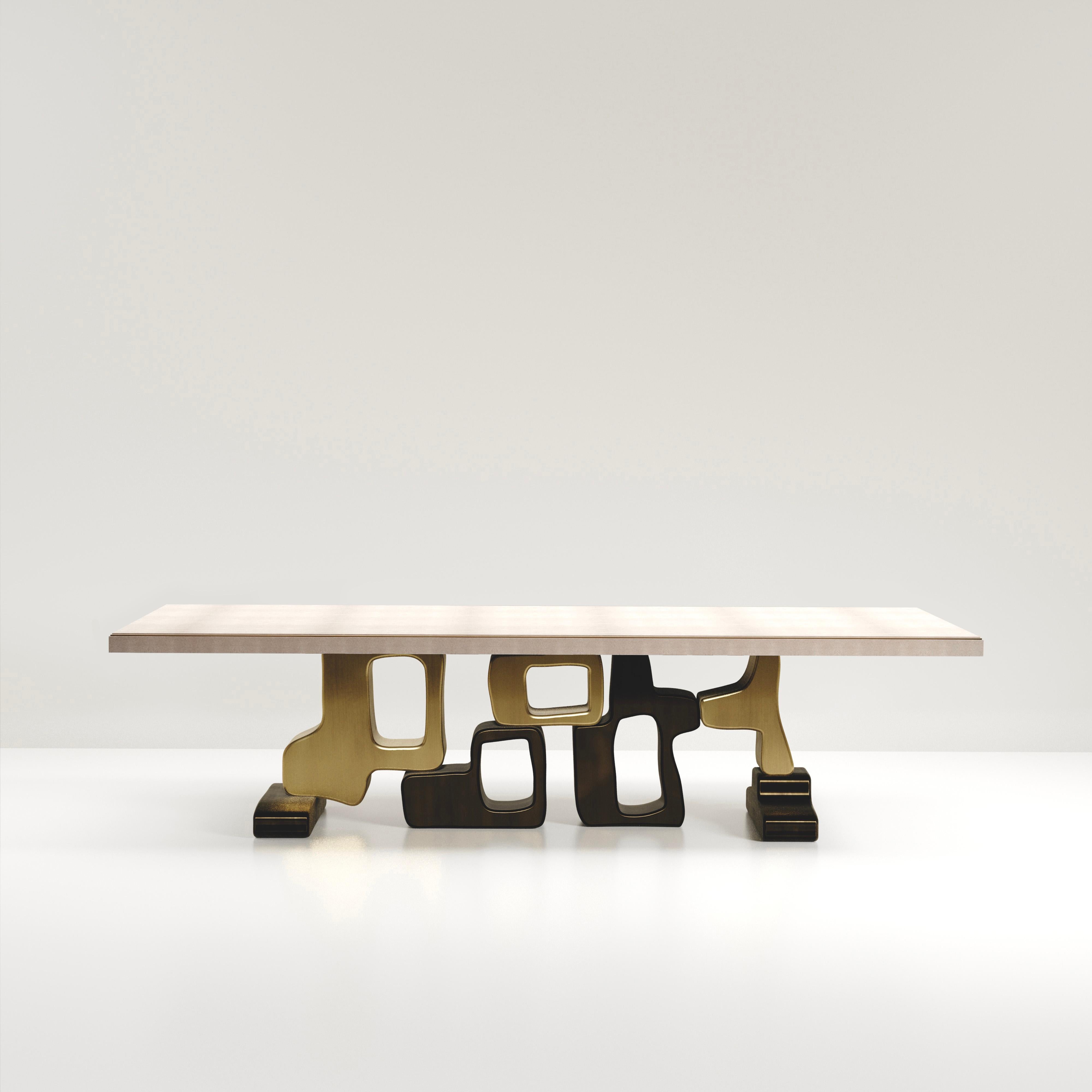 The Apoli II dining table by Kifu Paris is both dramatic and organic its unique design. The cream shagreen inlaid top sits on a long clustered geometric and sculptural bronze-patina brass base. This piece is designed by Kifu Augousti the daughter of