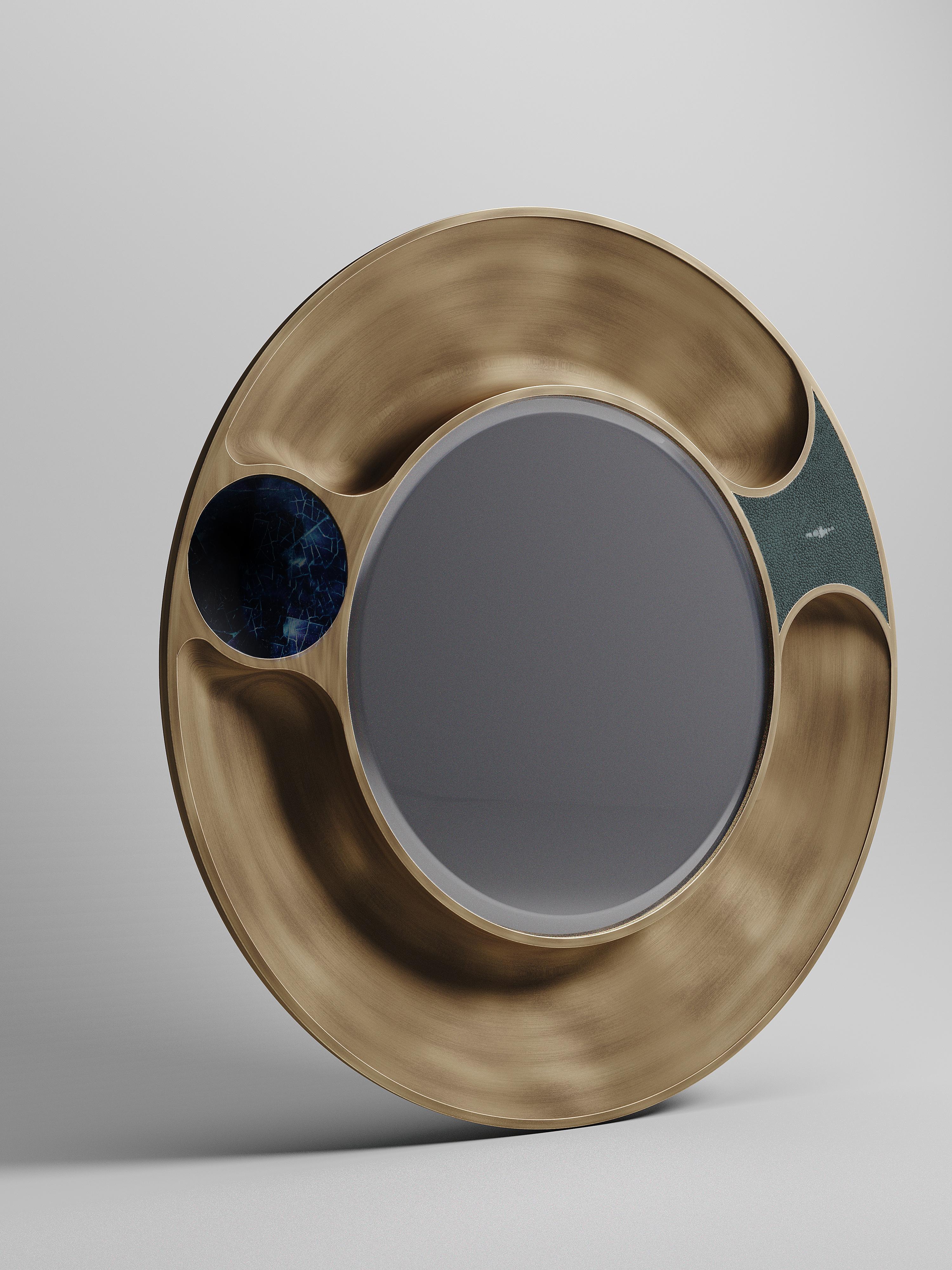 Le miroir Iris de R&Y Augousti est une pièce élégante et polyvalente. Interprétation abstraite d'un œil, la pièce est incrustée d'un mélange de galuchat bleu, de coquille de stylo bleue et de laiton patiné bronze. Couleurs et tailles personnalisées