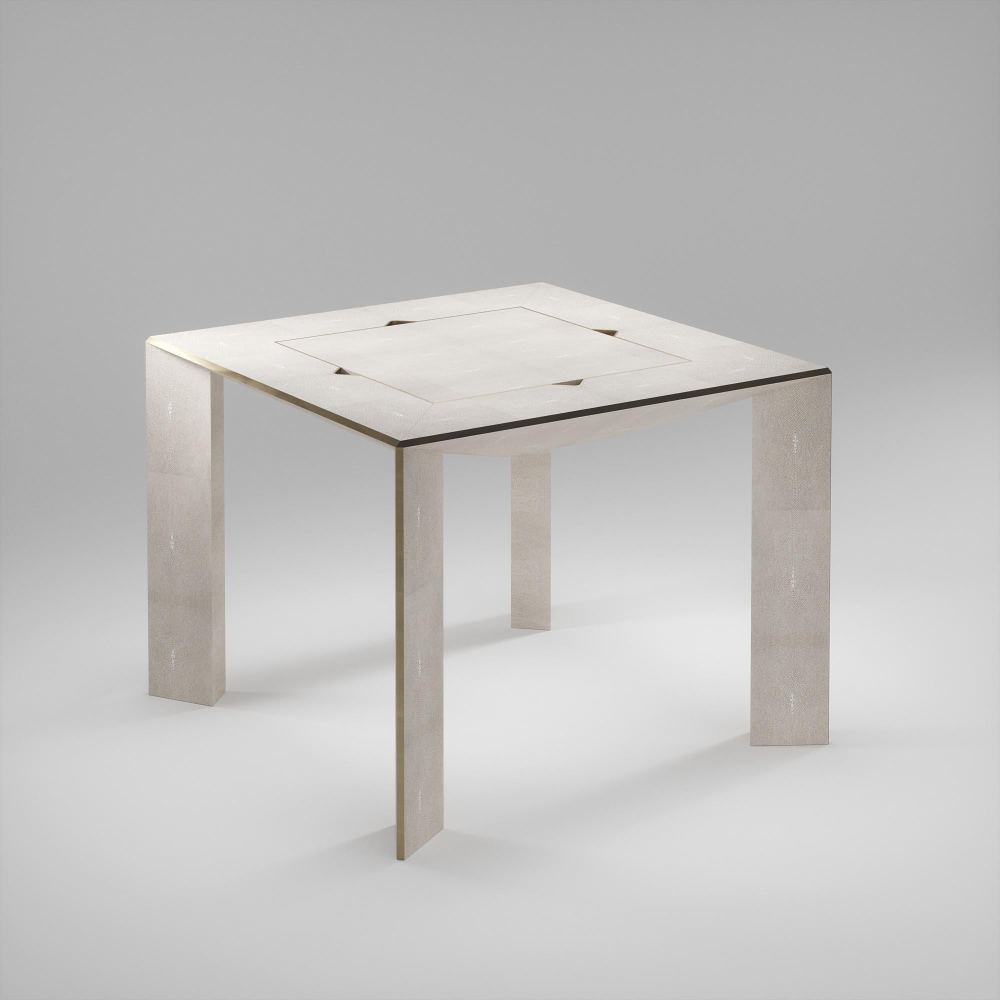 La table de jeu Parsons 4 en 1 R&Y Augousti est une pièce de luxe pour votre maison. Les lignes épurées de l'ensemble du meuble en galuchat crème, accentuées par les détails élégants en laiton bronze-patina sur les pieds, en font un meuble
