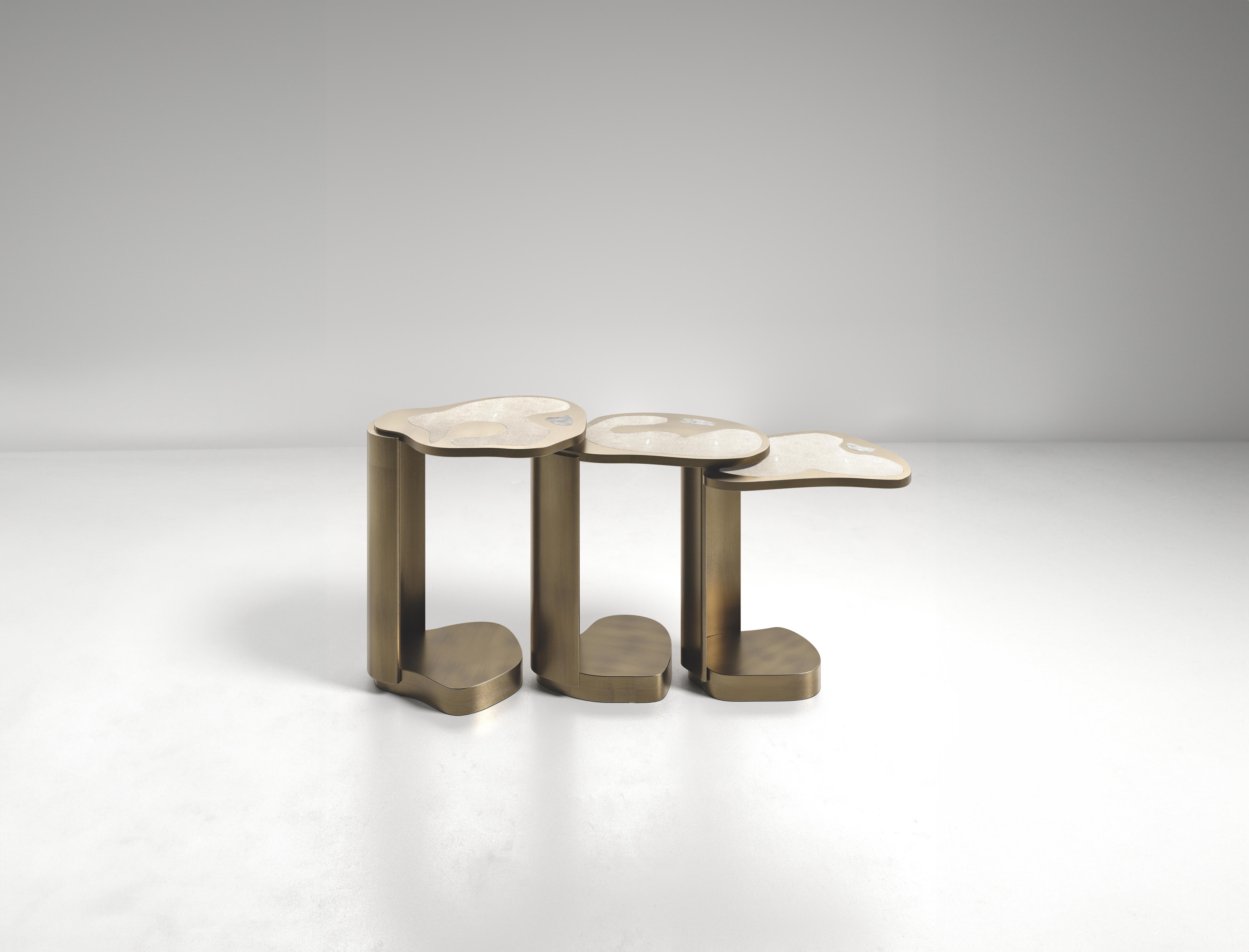 The Mask Nesting Side Tables by Kifu Paris are versatile and organic pieces. The amorphous tops and bases are inlaid in a mixture of cream shagreen, white quartz and bronze-patina brass. This piece is designed by Kifu Augousti the daughter of Ria