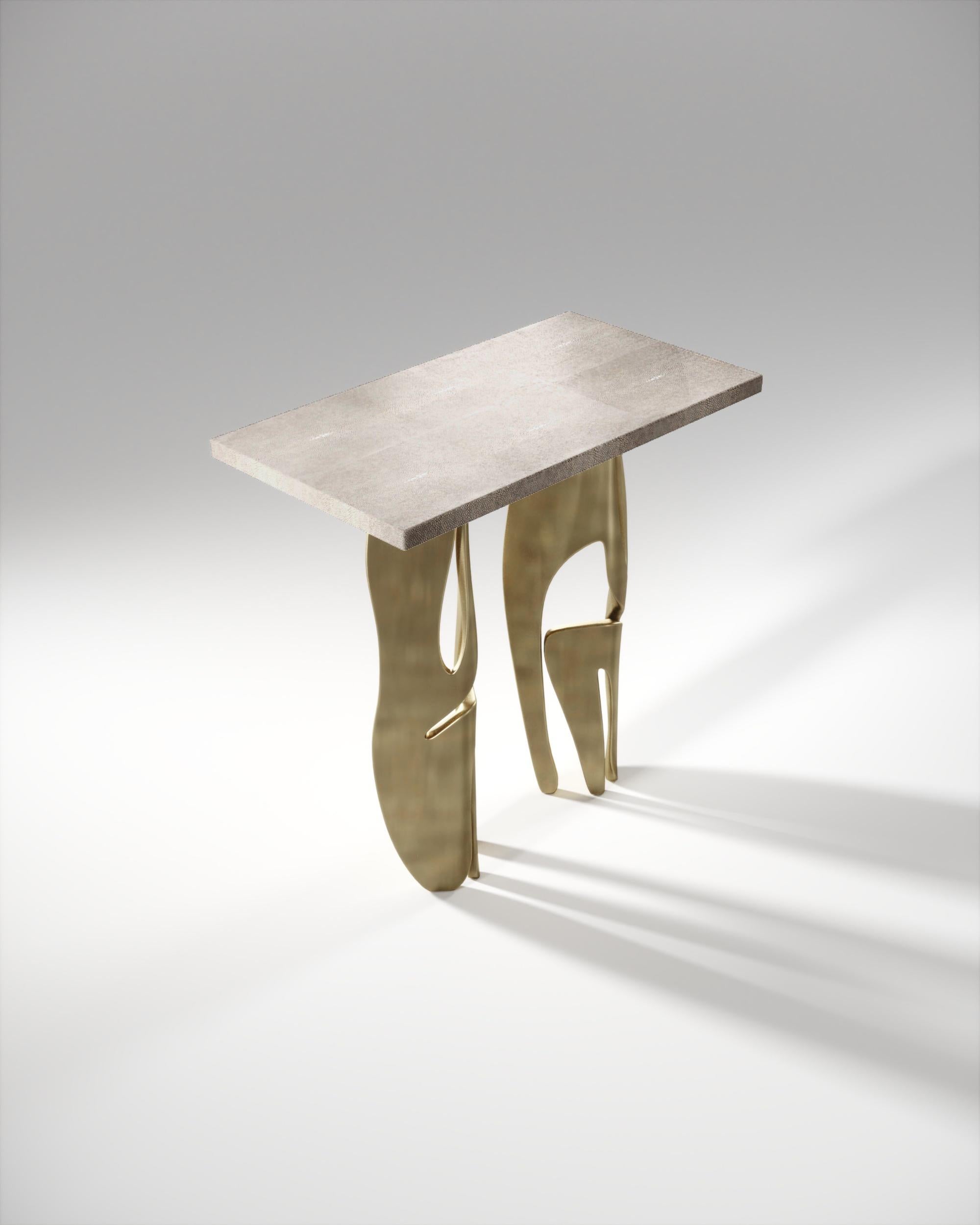 The metropolis rectangle side table by R&Y Augousti is both dramatic and organic it’s unique design. The cream shagreen inlaid top sits on a pair of ethereal and sculptural bronze-patina brass legs. This piece makes for the perfect end table and is
